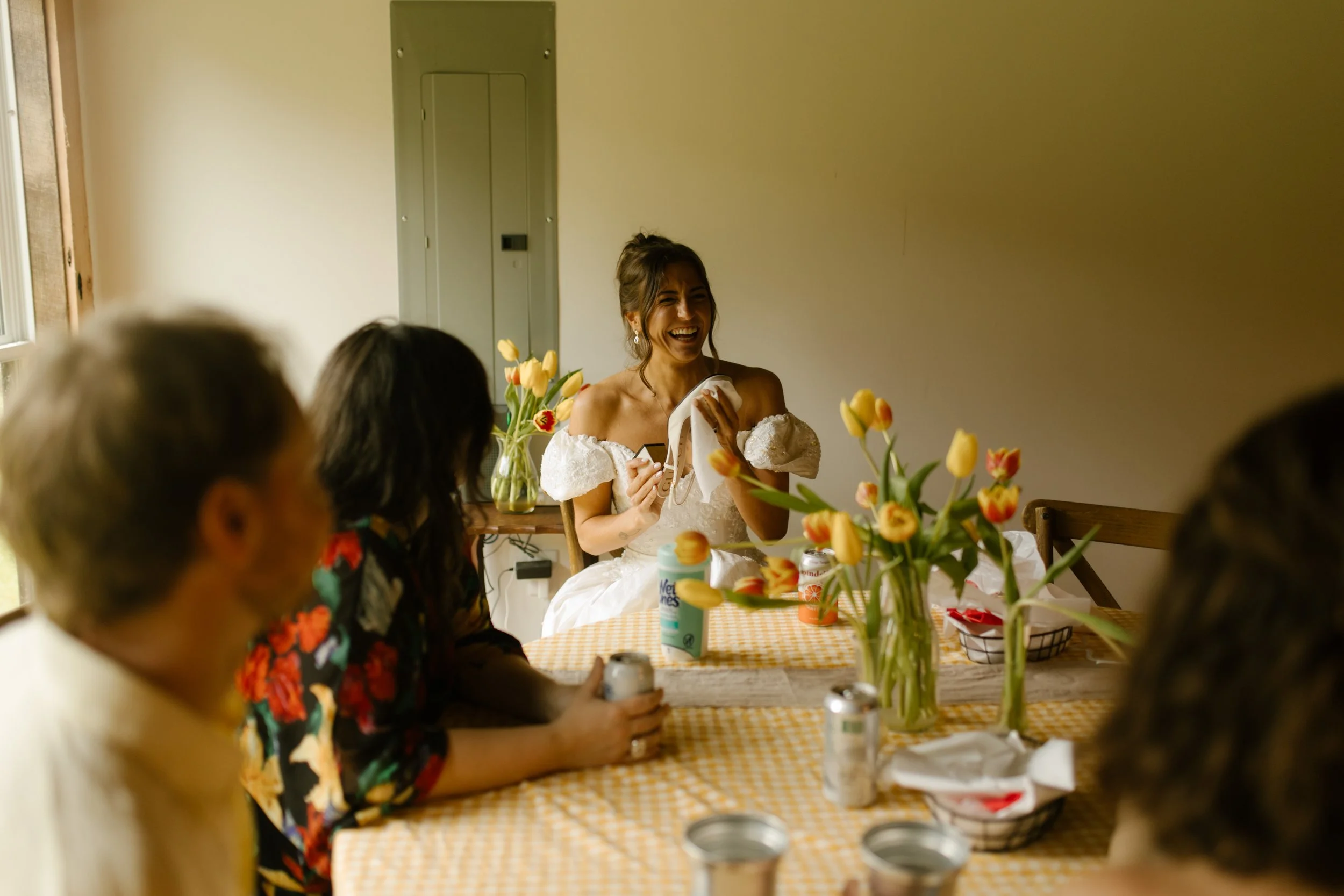 Bride sharing stories with friends around a table during the wedding rehearsal dinner