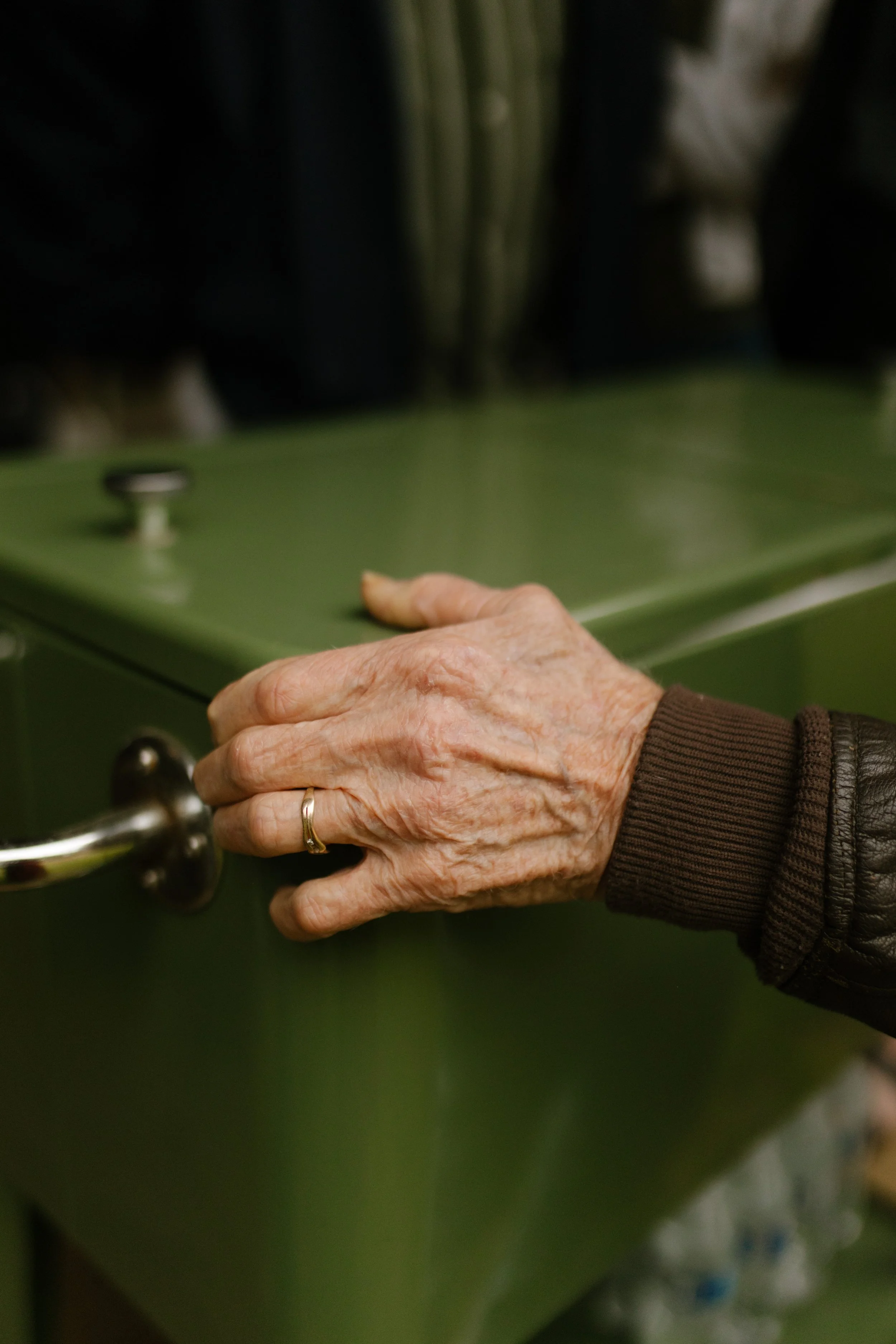 Close-up of an older guest opening a serving station during the wedding rehearsal dinner.