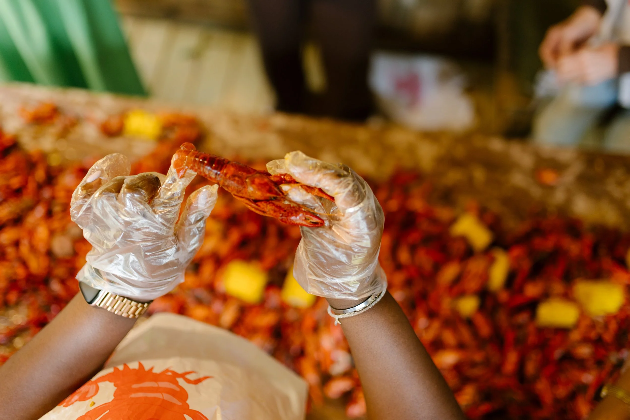 Guest holding a crawfish over a traditional Southern crawfish boil table