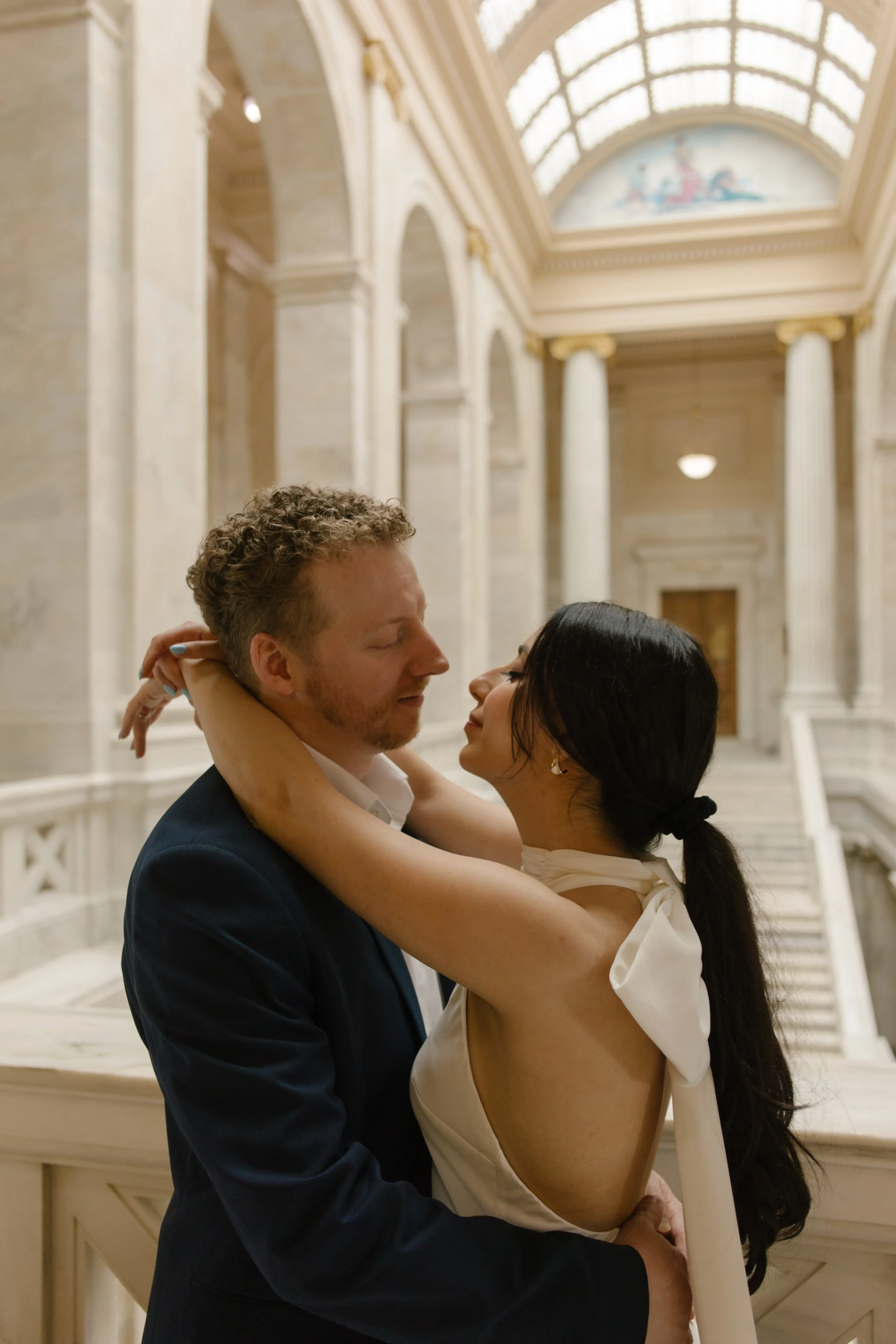 Romantic portrait of an engaged couple surrounded by the historic architecture of the Little Rock Courthouse