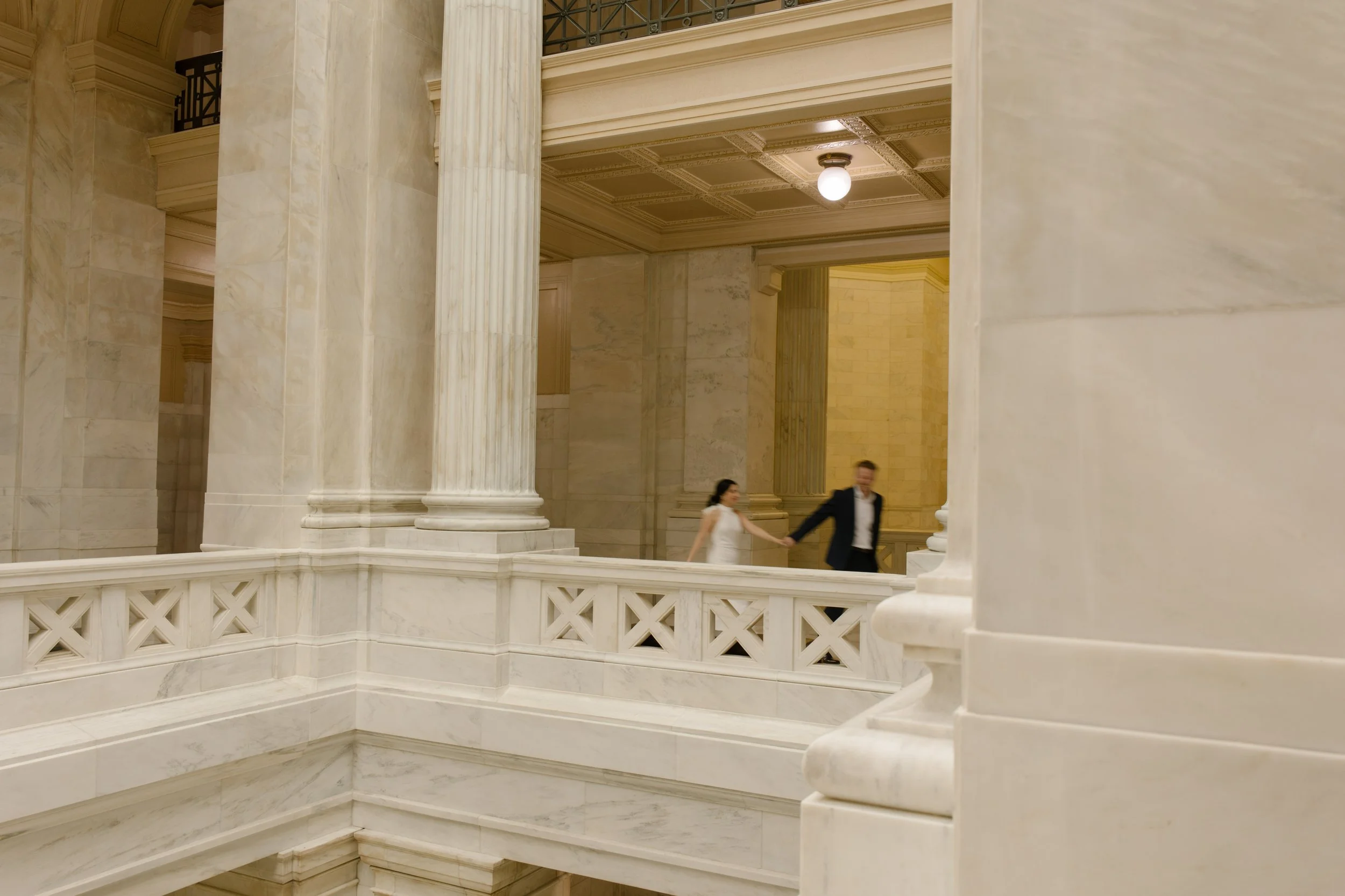 Couple walks hand in hand through the grand interior corridors of the Little Rock courthouse.