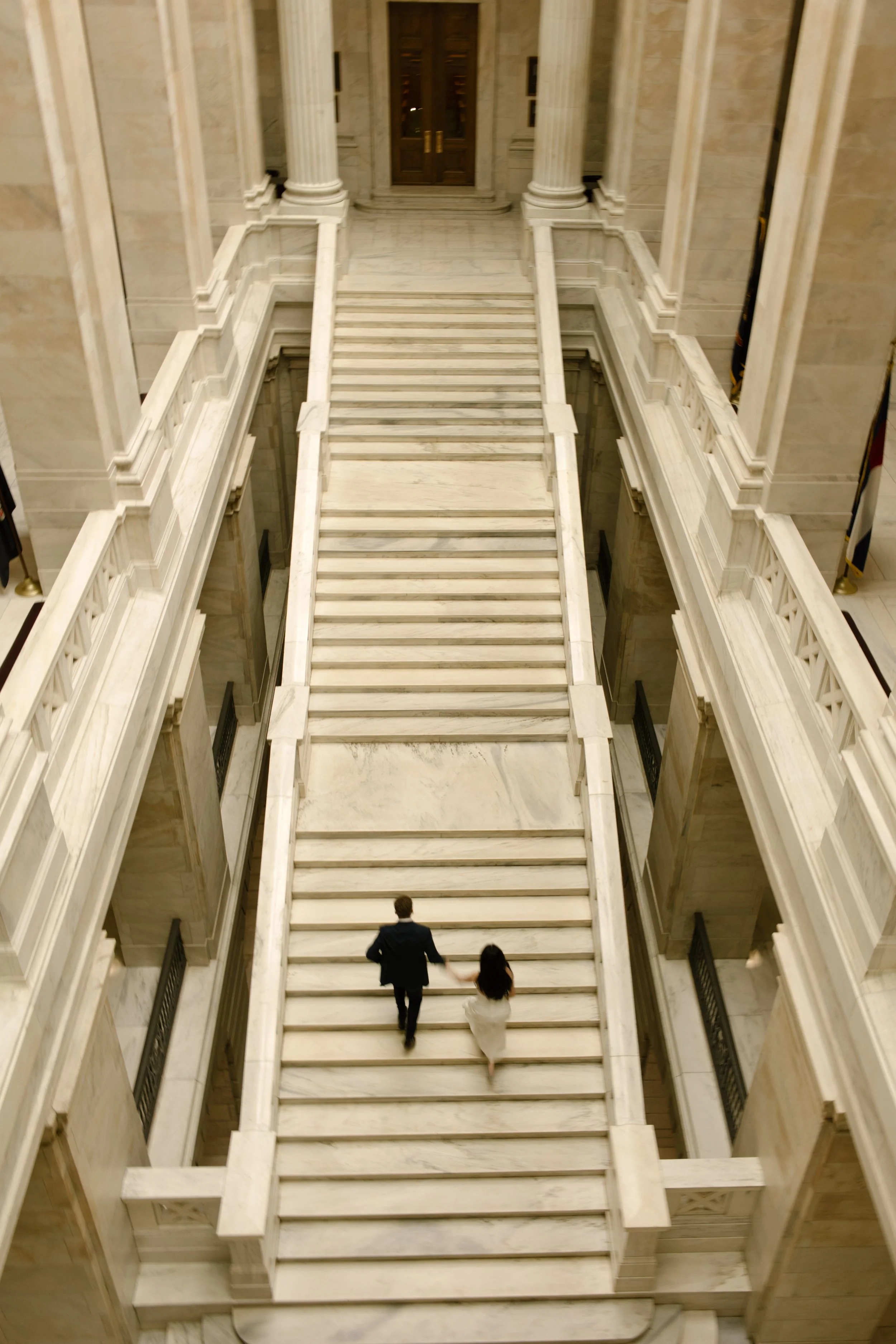 Overhead view of a couple walking together across the iconic staircase inside the courthouse