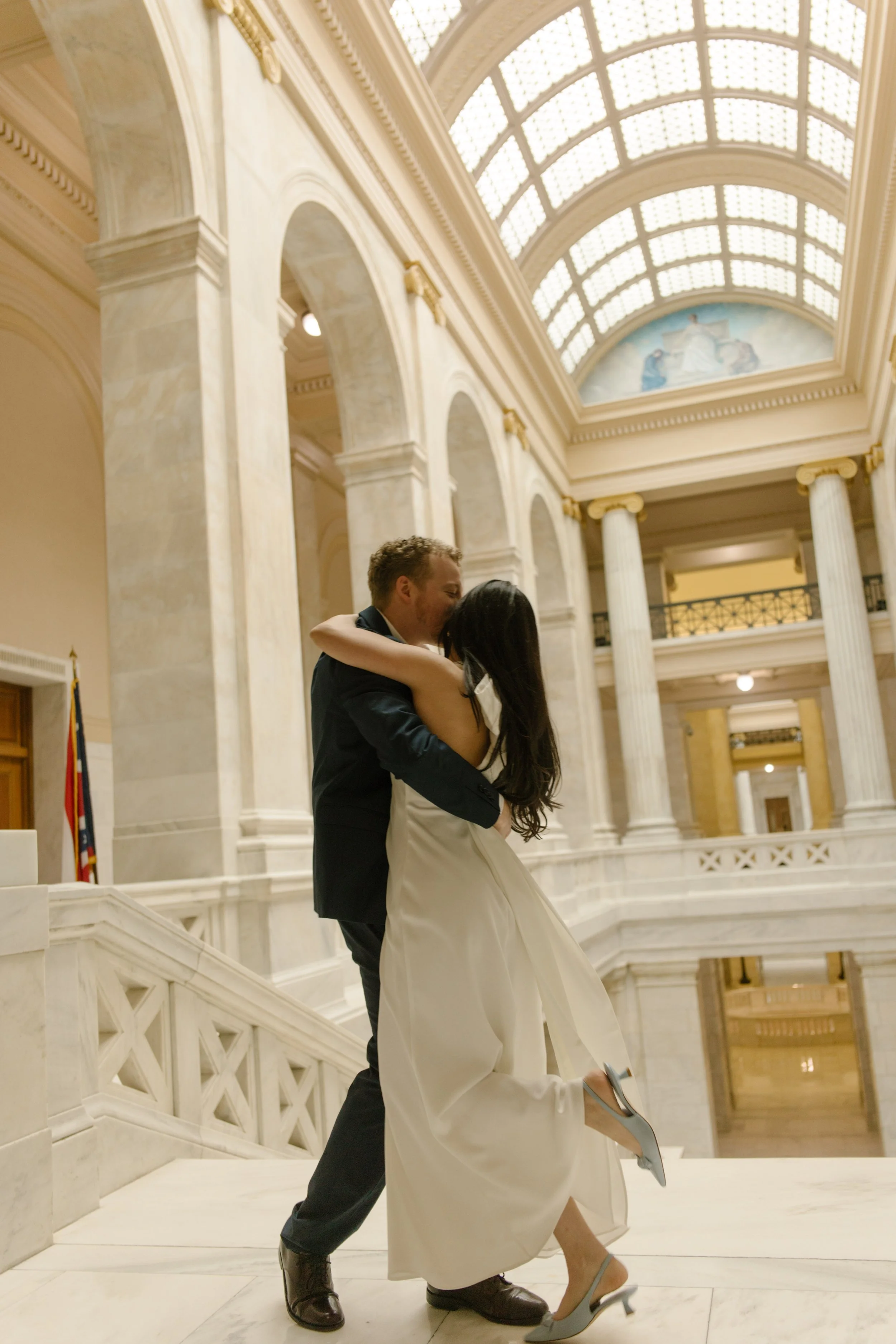 Romantic kiss beneath the marble arches inside the Little Rock Courthouse