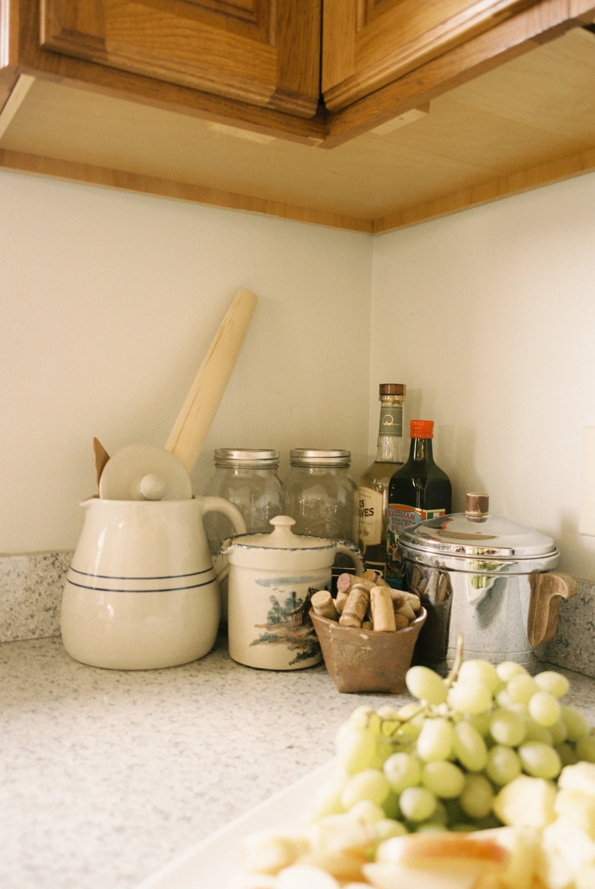 Vintage kitchen counter with grapes, serving pieces, and wedding-day refreshments prepared for guests.