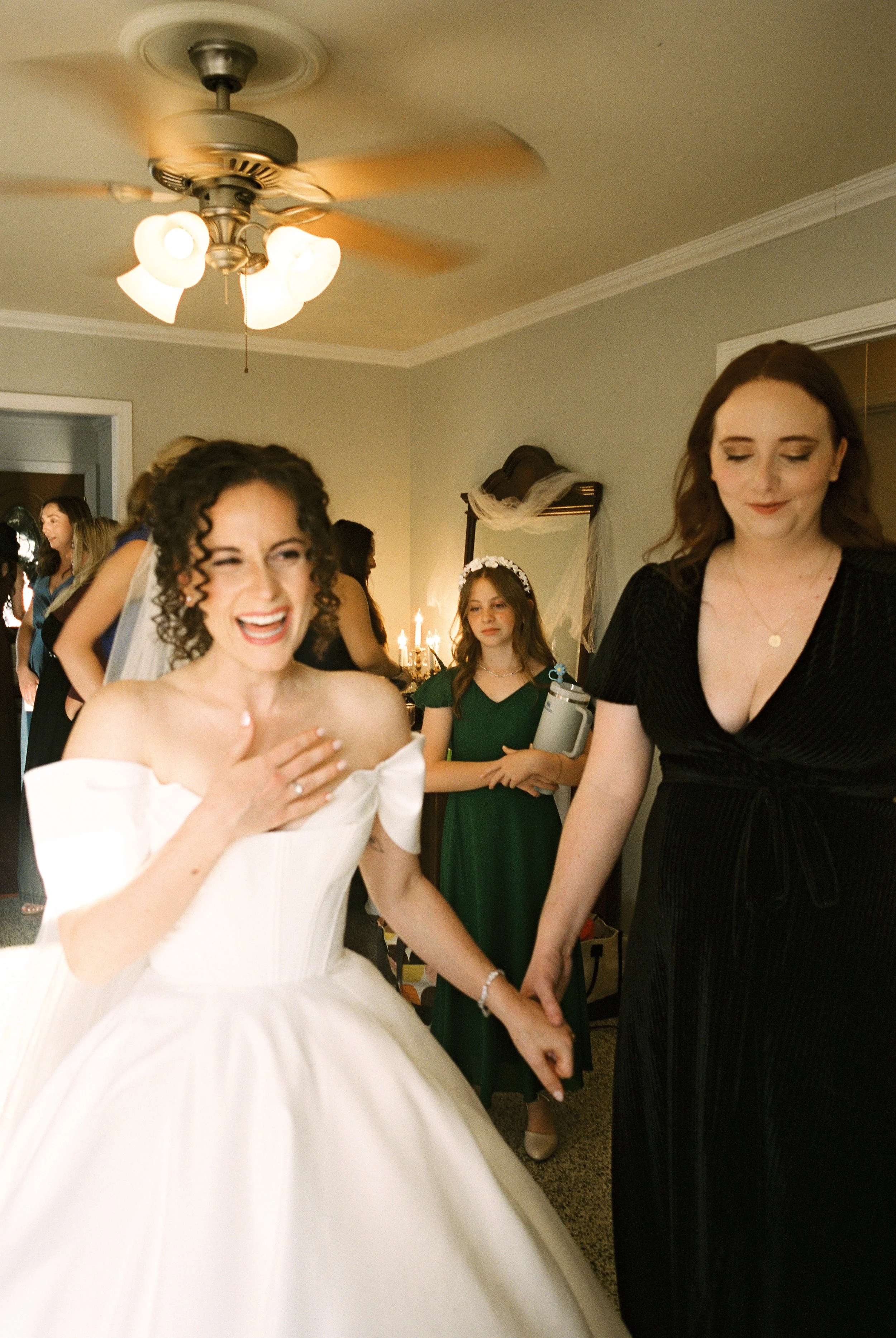Bride laughs while entering the room with loved ones before the ceremony in an authentic documentary wedding photography moment.