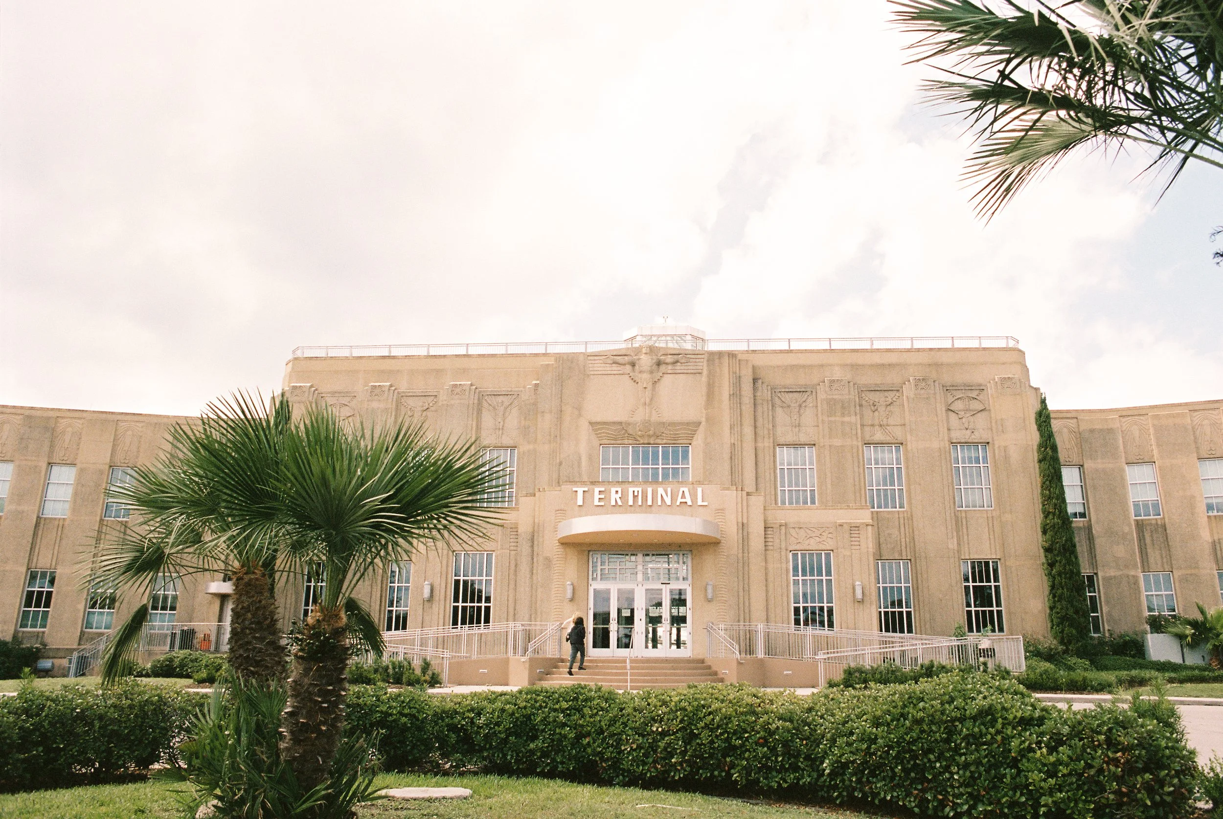 Historic airport terminal building exterior before the wedding celebration, captured through documentary wedding photography.