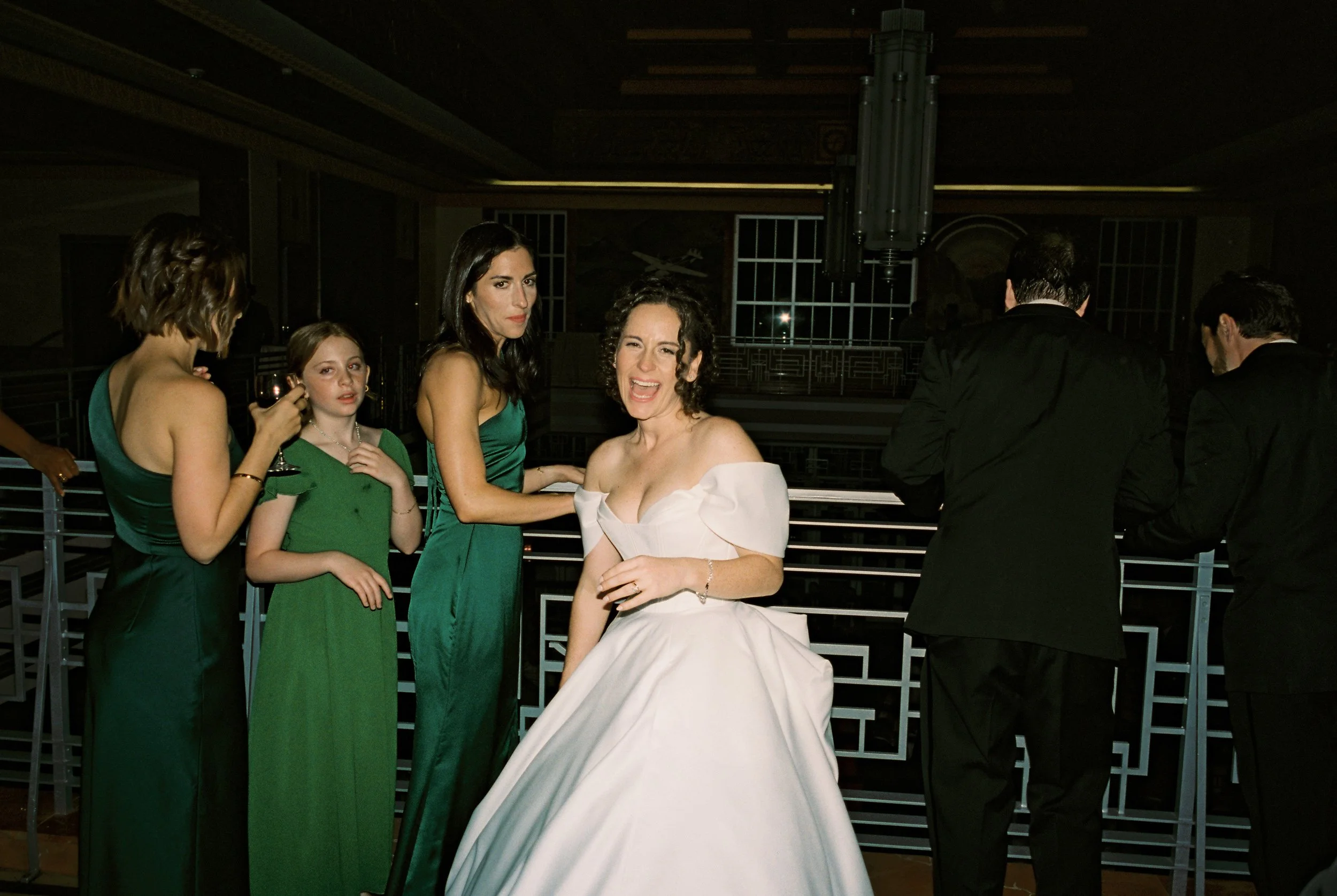 Bride laughs with bridesmaids and family members during the reception in a candid documentary wedding photography moment.