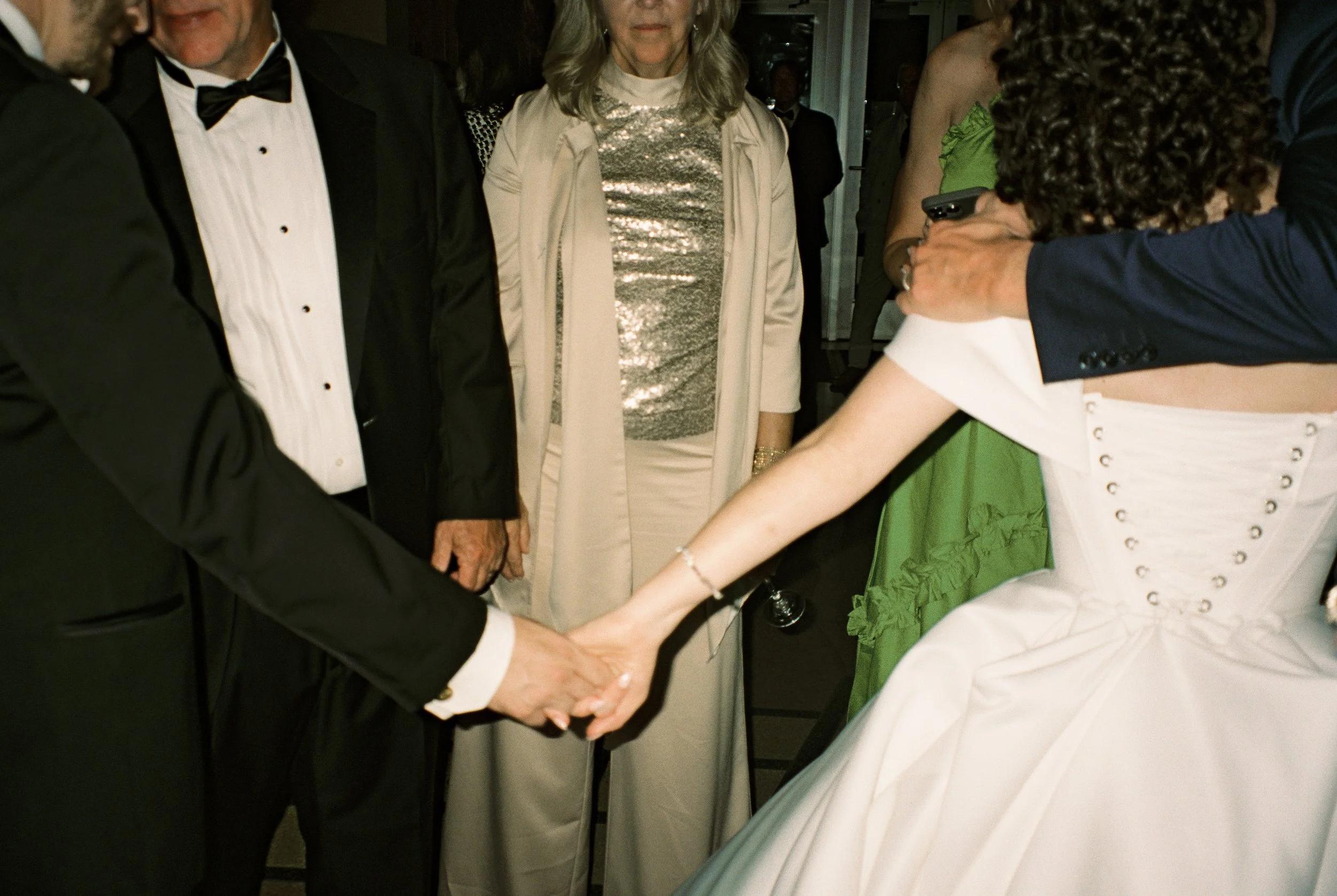 Bride shares a dance with a family member while loved ones gather around the dance floor during the reception.