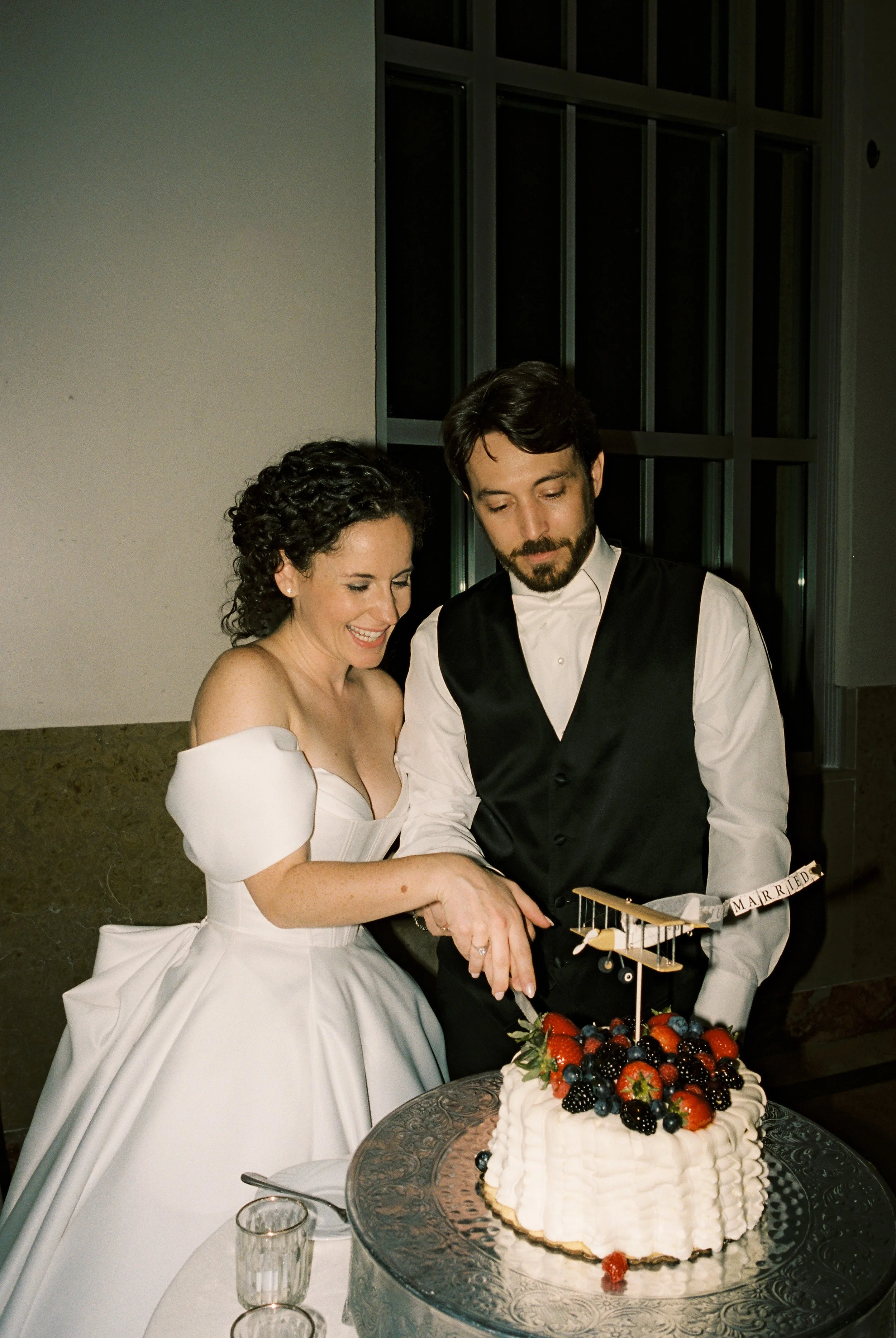 Couple cuts their wedding cake together during the reception celebration.