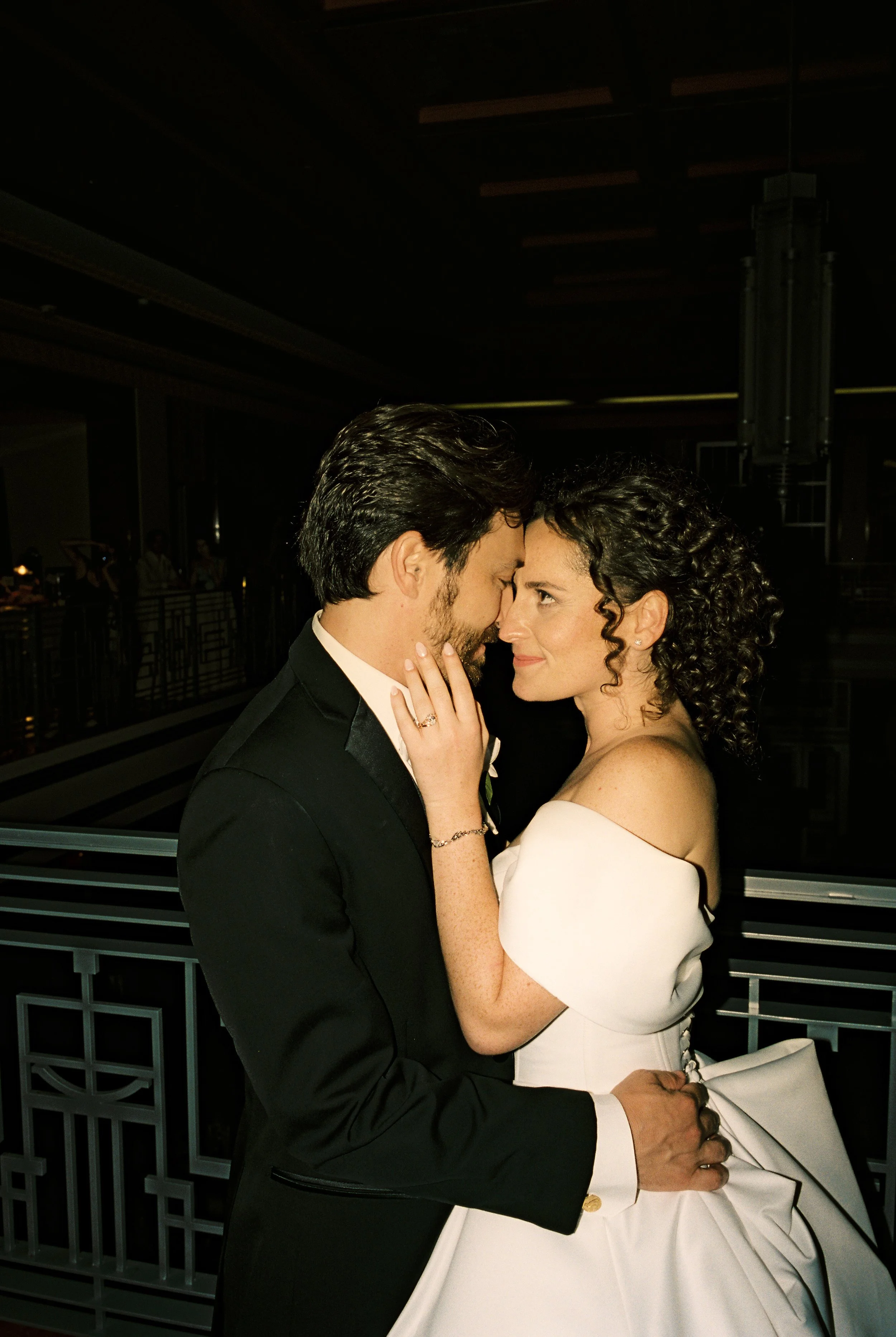 Romantic reception portrait of the newly married couple embracing and gazing at each other in elegant evening light.