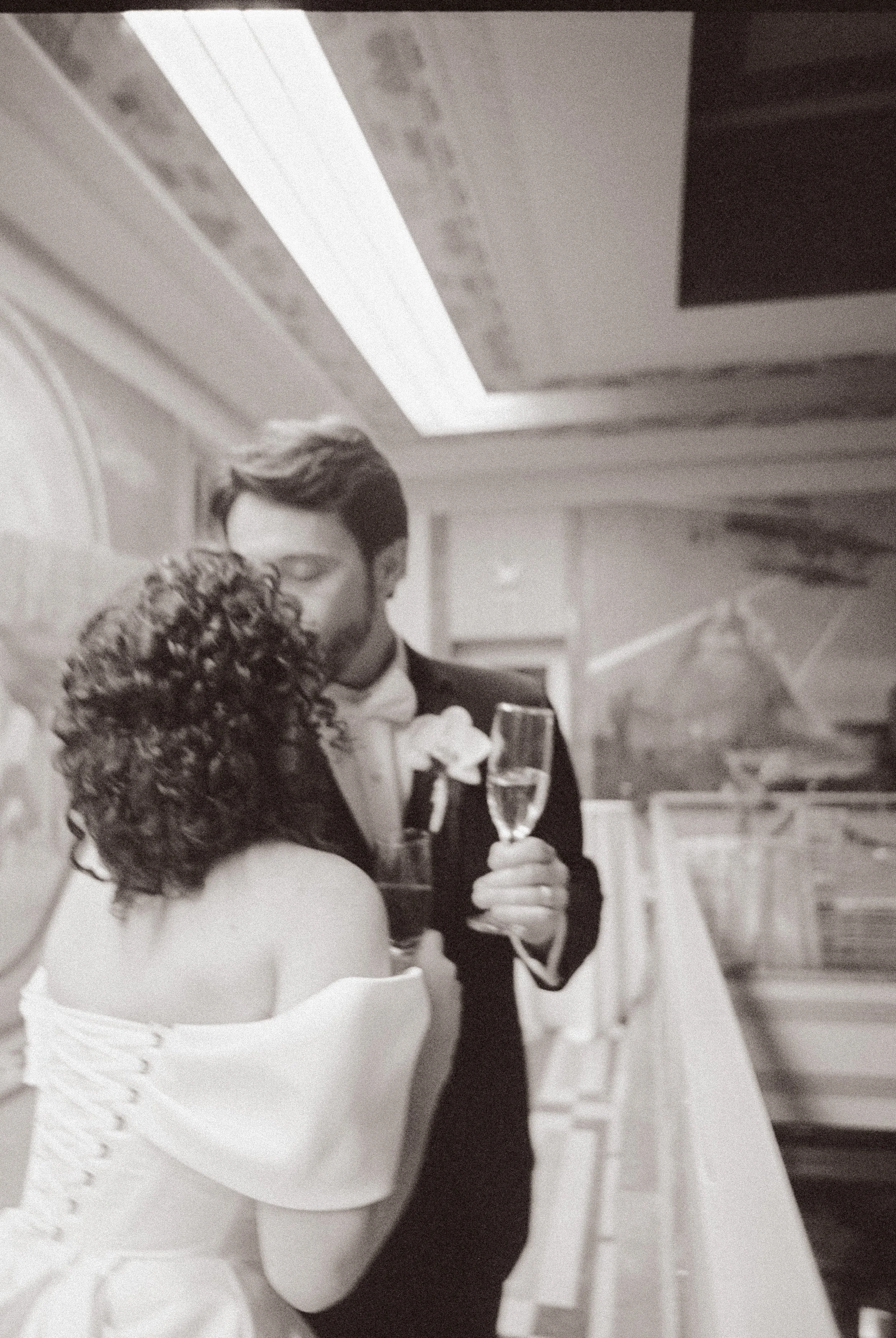 Newlyweds share a quiet moment with champagne on an upper-level balcony during the reception.