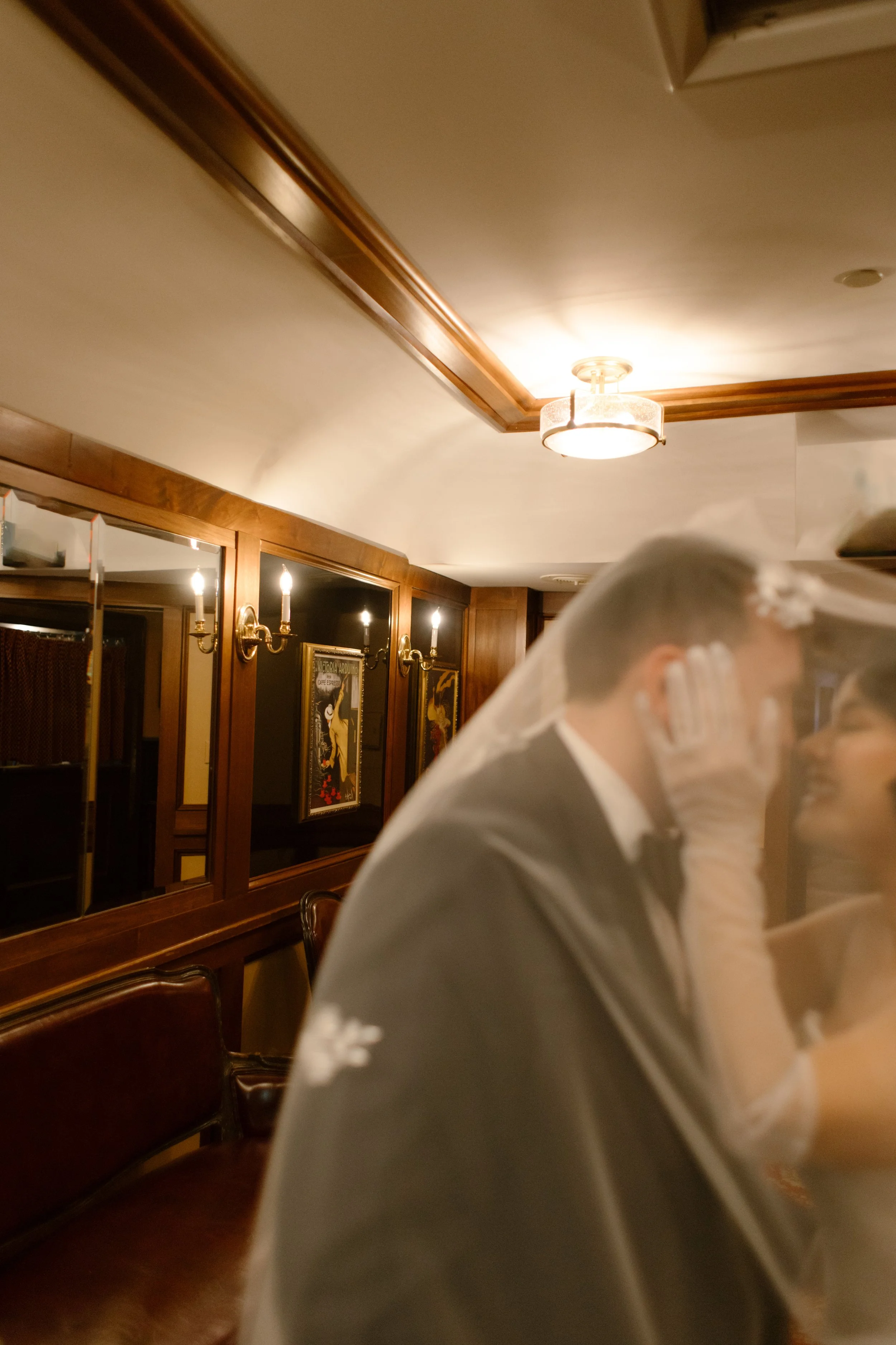 Newlyweds embrace beneath the wedding veil inside a vintage railcar, creating an intimate moment at one of the most unique Wedding Locations in NYC.