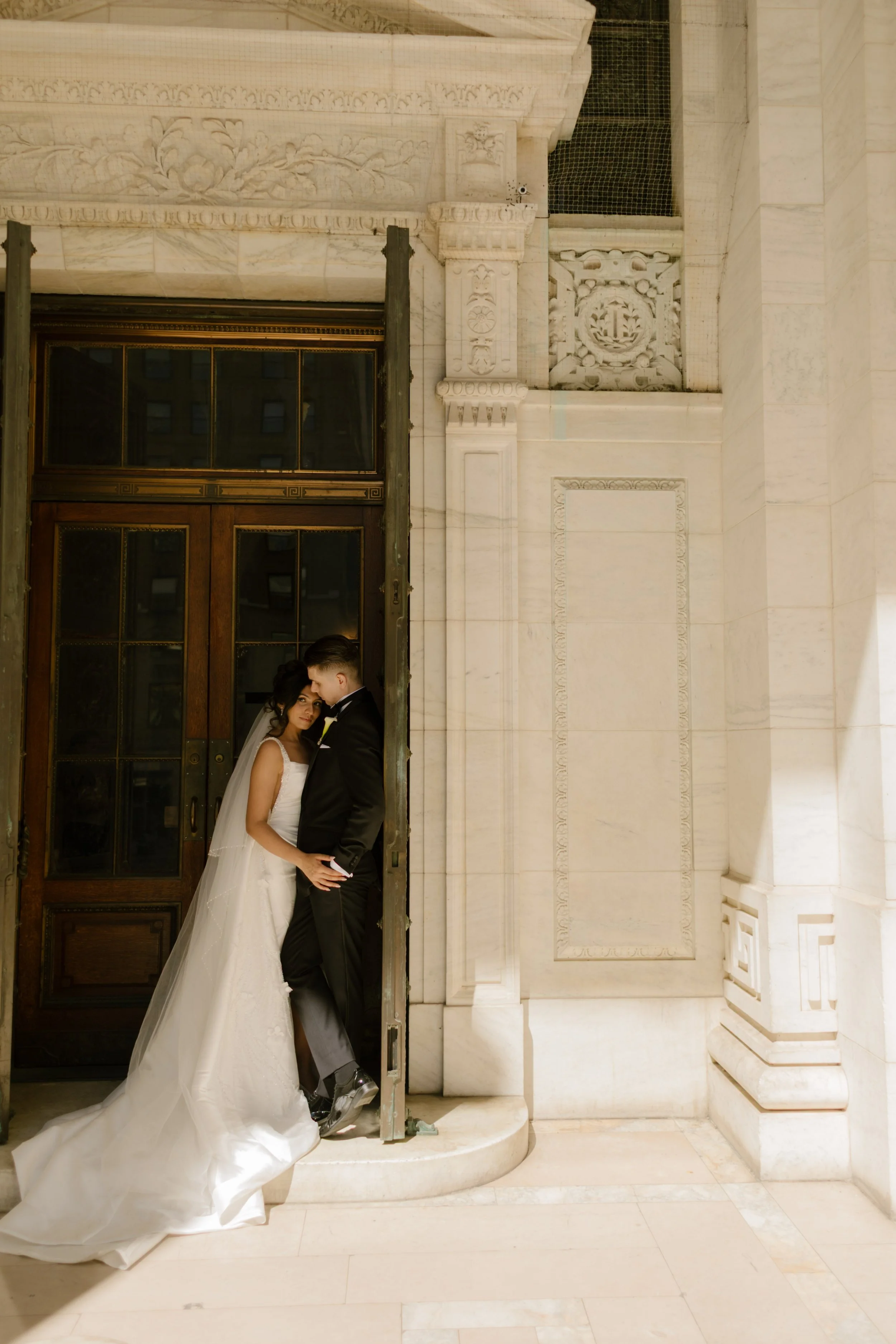 Bride and groom embrace in a marble doorway at one of the most elegant Wedding Locations in NYC for timeless wedding portraits.
