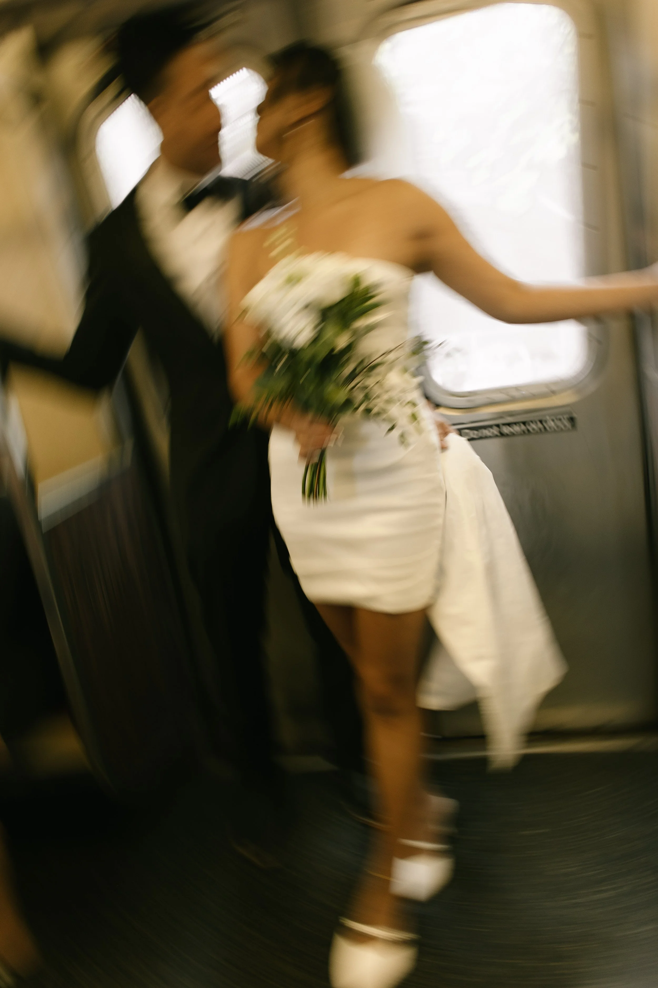 Motion blur of a newlywed couple riding the subway after their NYC courthouse wedding, capturing the energy and spontaneity of their wedding day in New York City.
