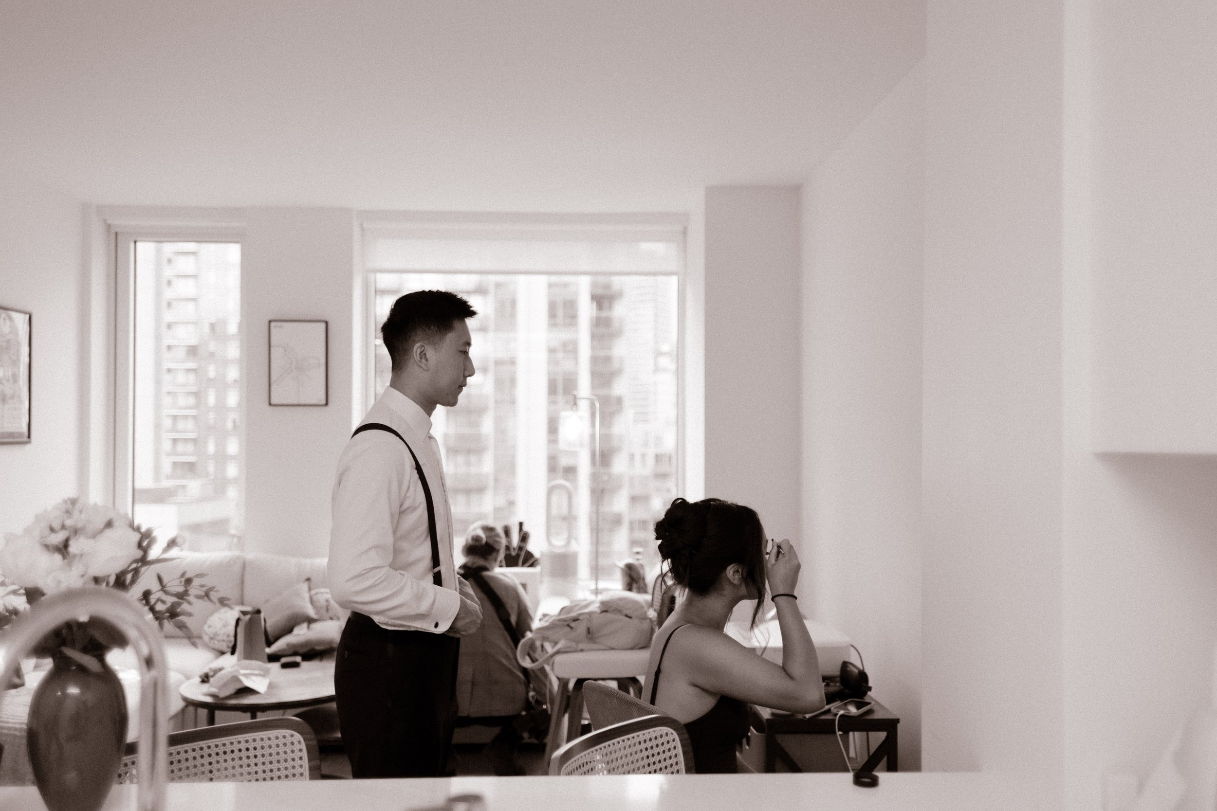 Bride and groom getting ready together in their apartment before heading to their wedding ceremony in Manhattan.
