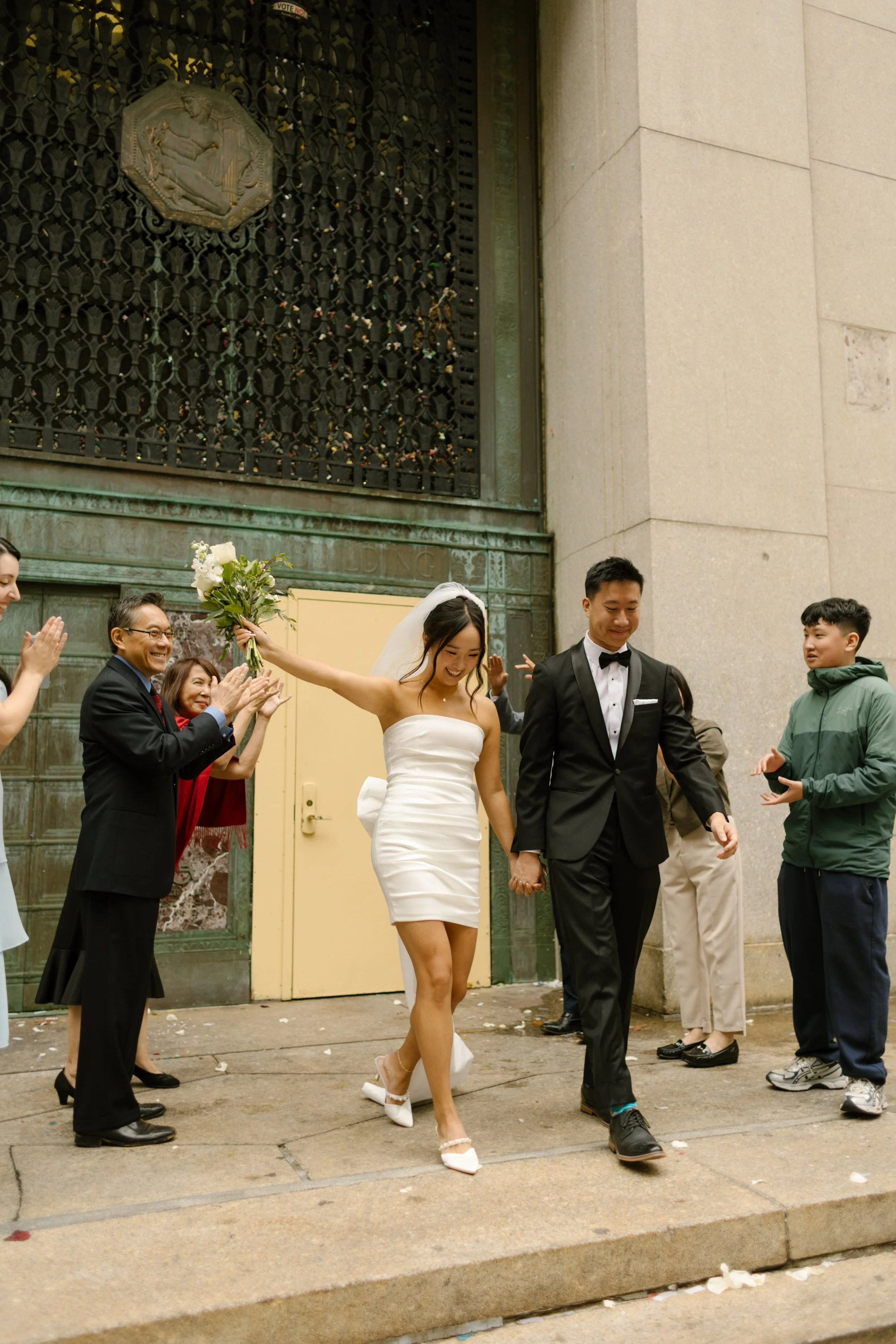 Bride and groom celebrate with family after their nyc courthouse wedding outside the Manhattan courthouse.