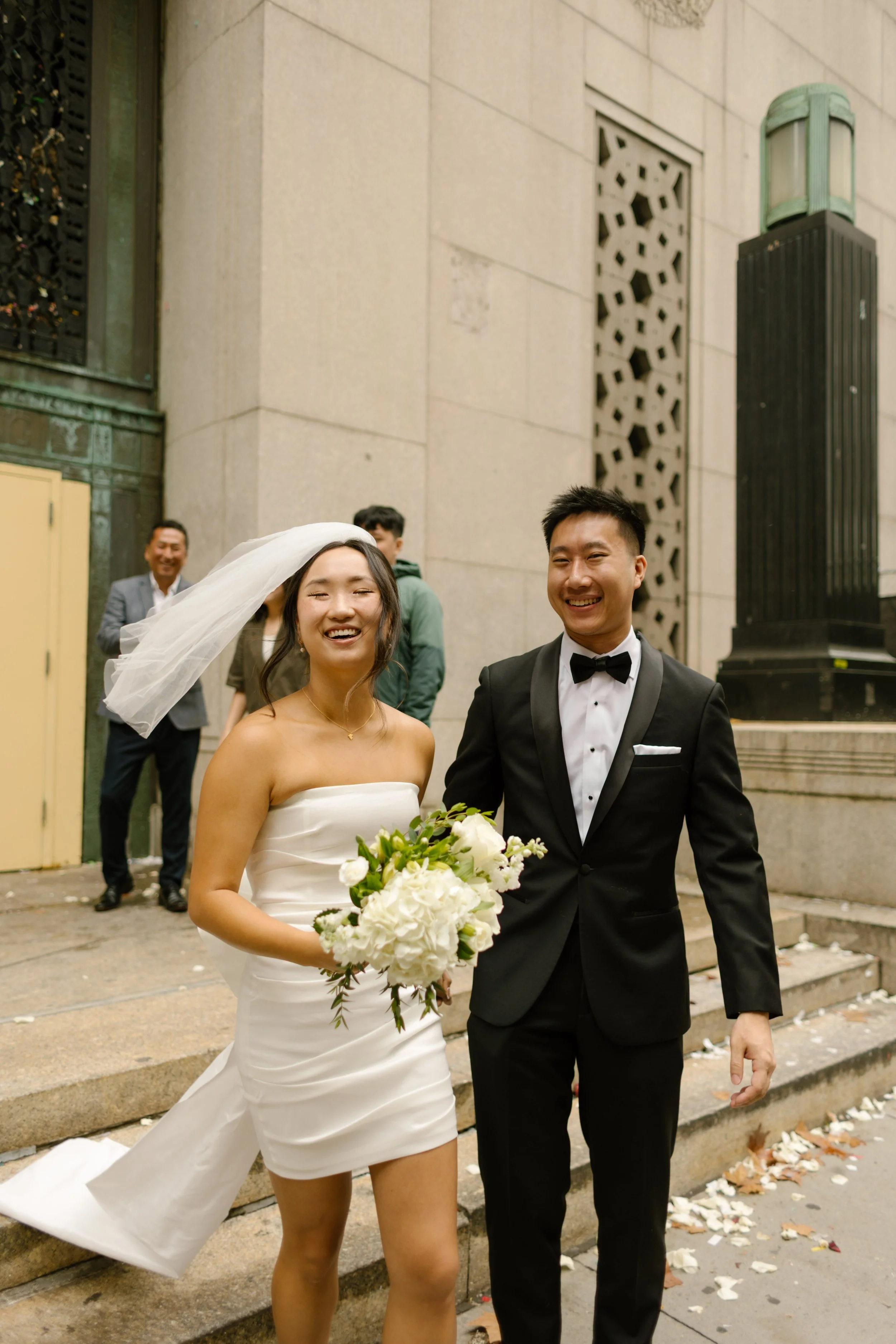 Bride and groom smile together outside the courthouse moments after their intimate New York City wedding celebration.