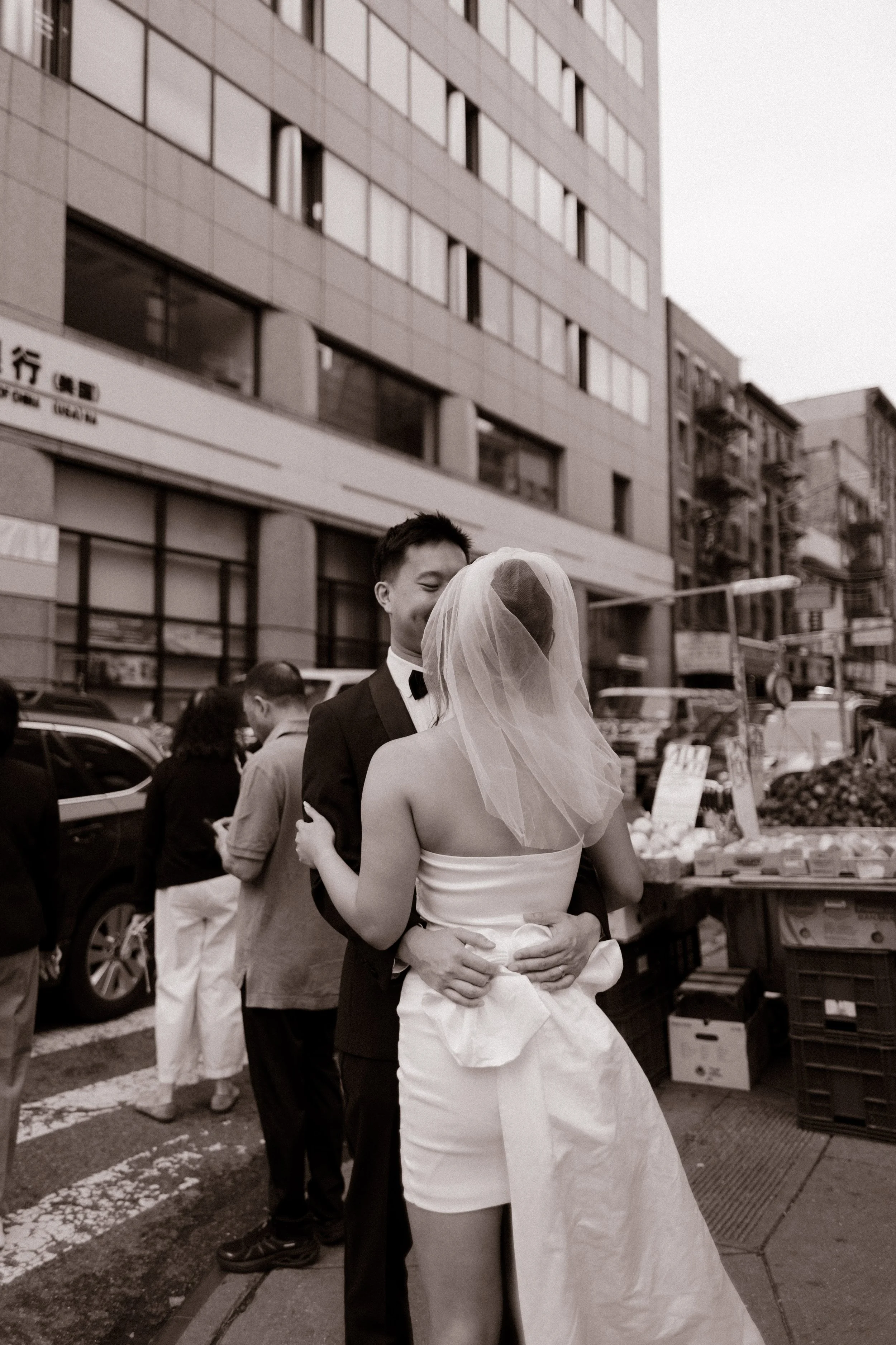 Bride carries a white bouquet through Little Italy following her intimate New York City courthouse wedding.