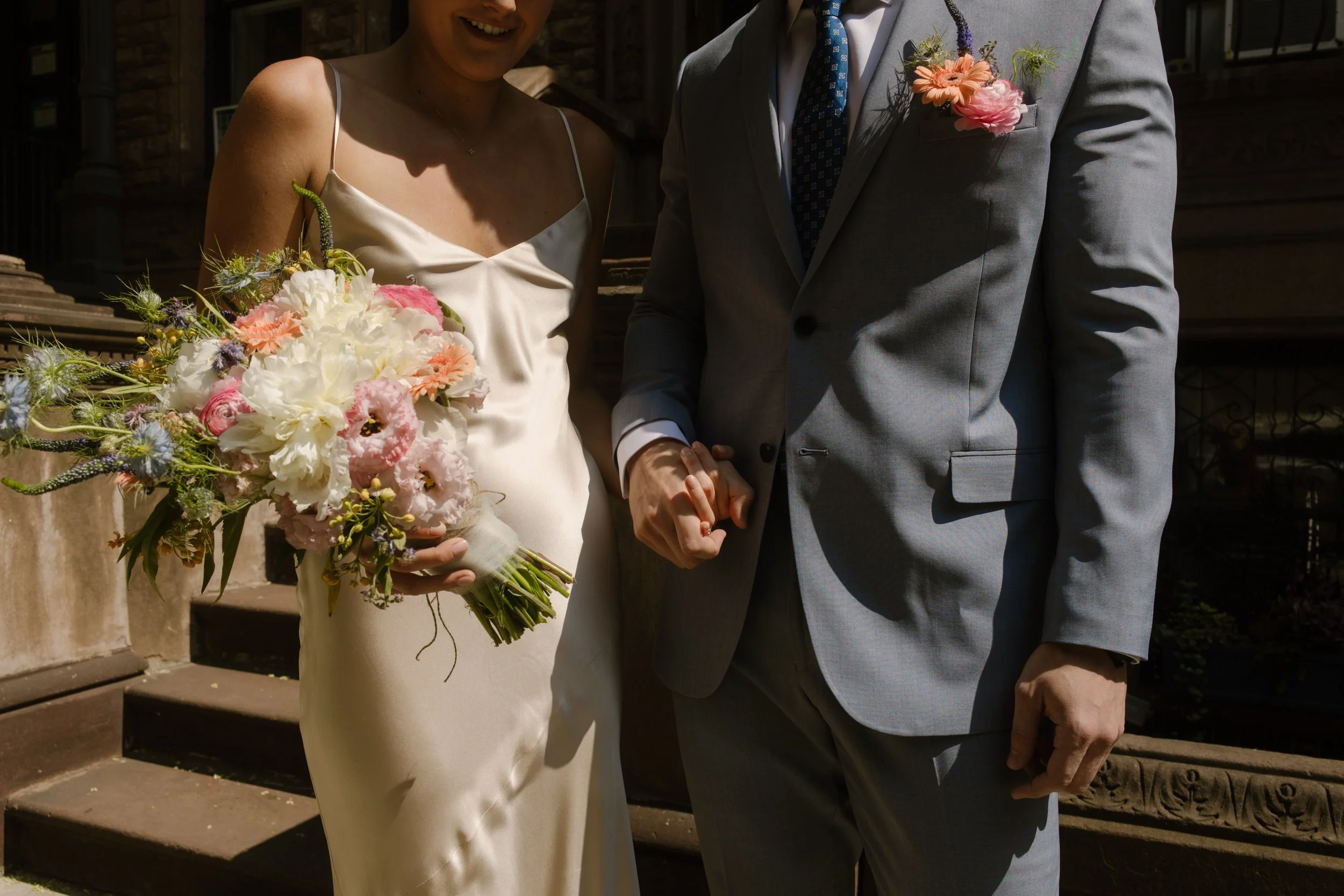 Bride and groom holding hands while walking together after their ceremony during their wedding day timeline portraits.