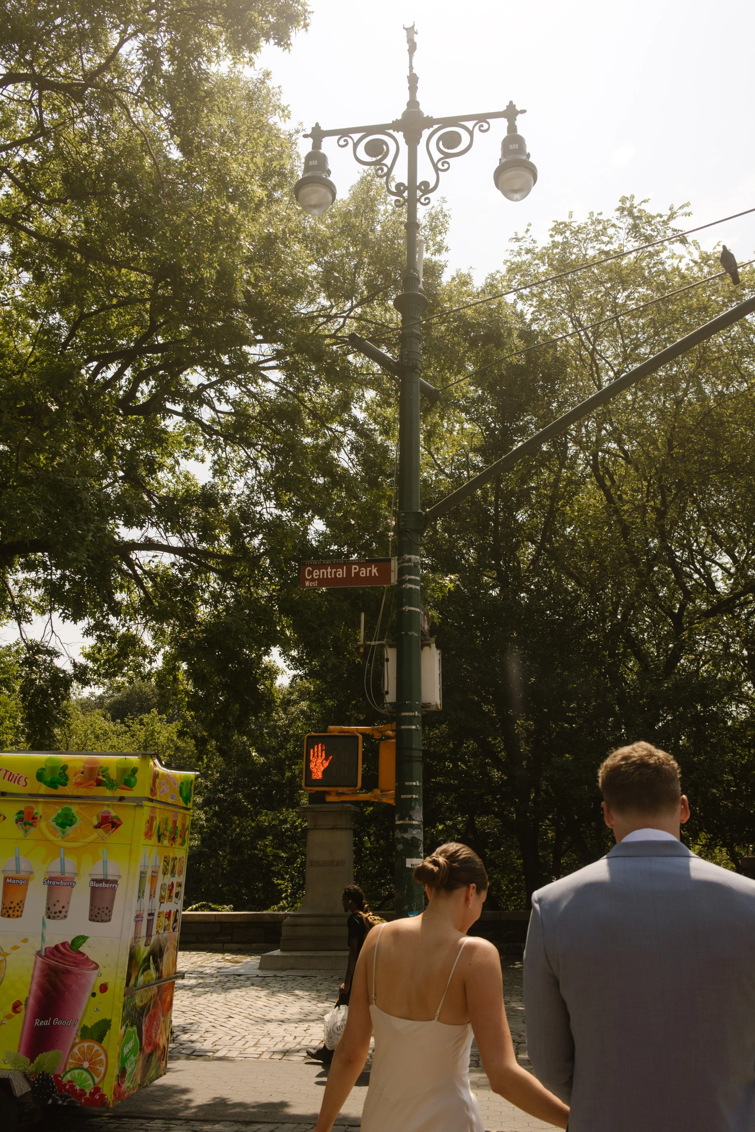 Newlyweds crossing the street together near Central Park as part of their wedding day timeline.