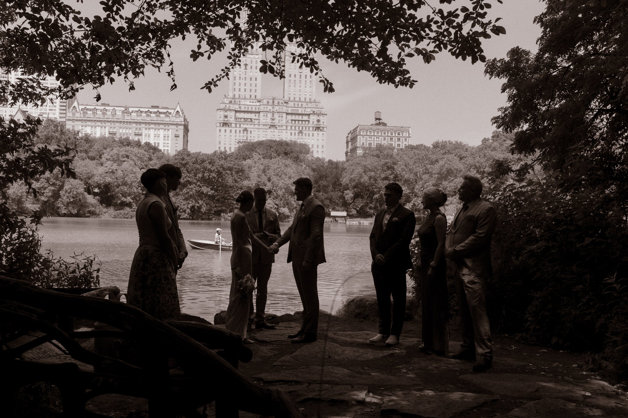 Black-and-white photo of an intimate lakeside wedding ceremony in Central Park.