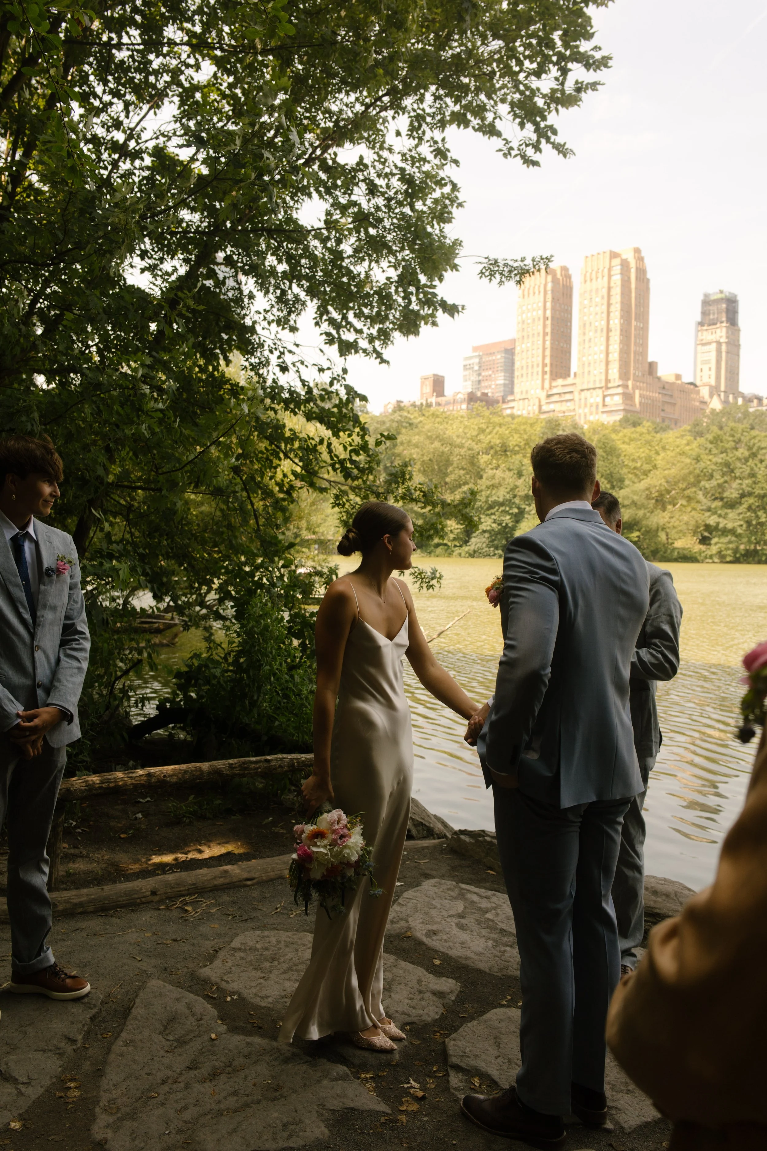 Couple gathering with family before exchanging vows beside the lake in Central Park.