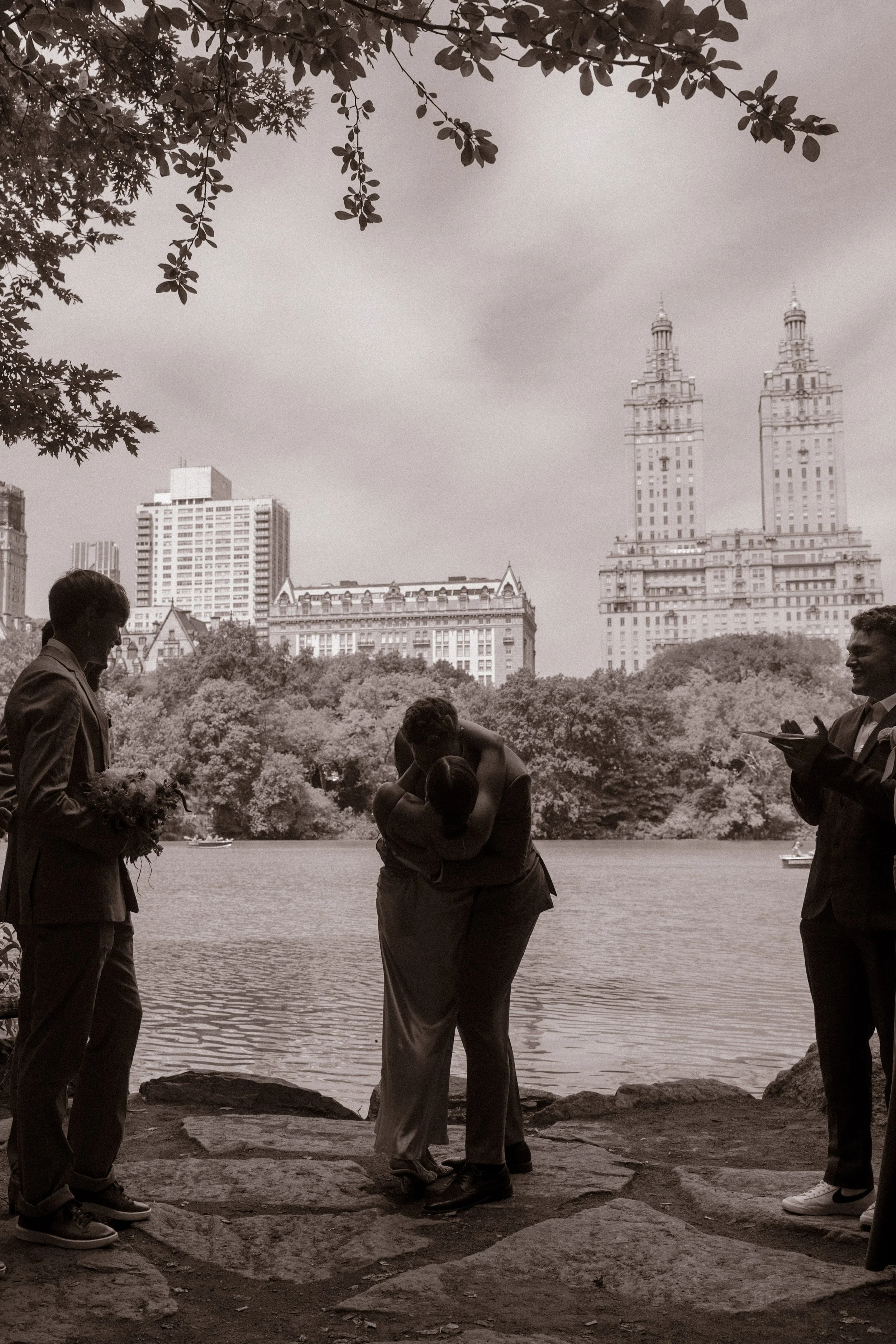 Black-and-white portrait of the couple sharing their first kiss after exchanging vows during their wedding day timeline.