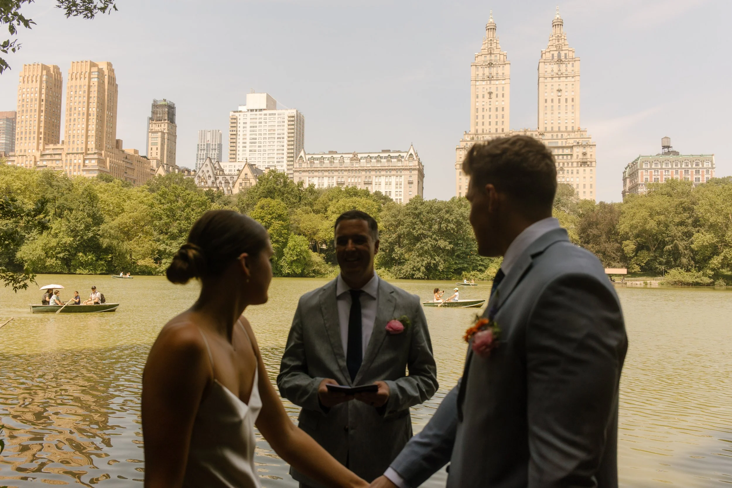 Bride and groom holding hands before exchanging rings during a heartfelt moment in the wedding day timeline.