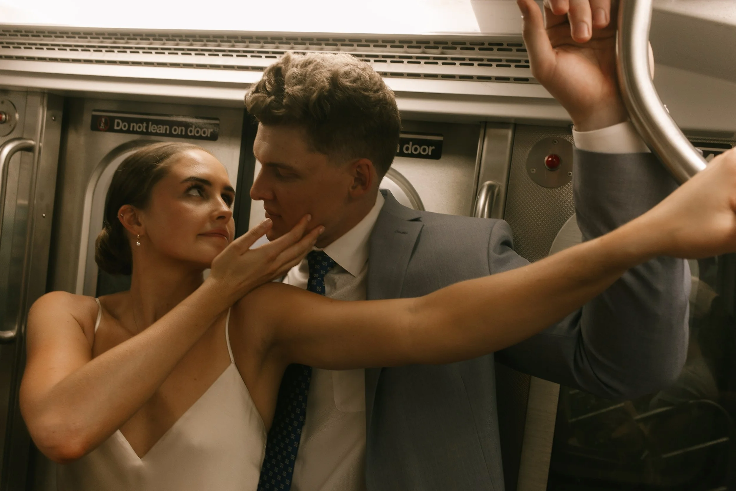 Bride and groom sharing a playful moment aboard a New York City subway as part of their wedding day timeline.