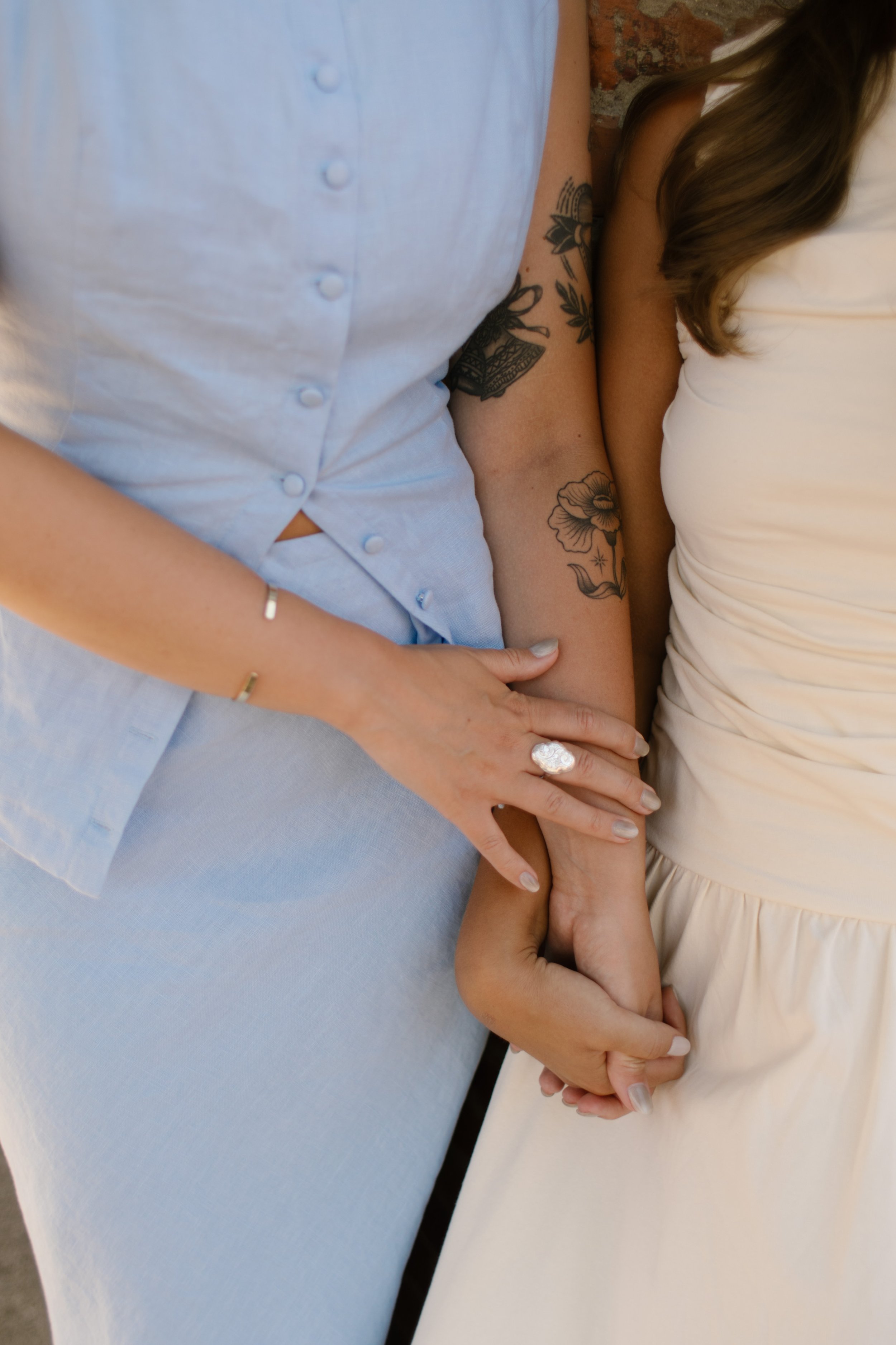 Close-up of intertwined hands featuring wedding rings during an intimate wedding portrait.