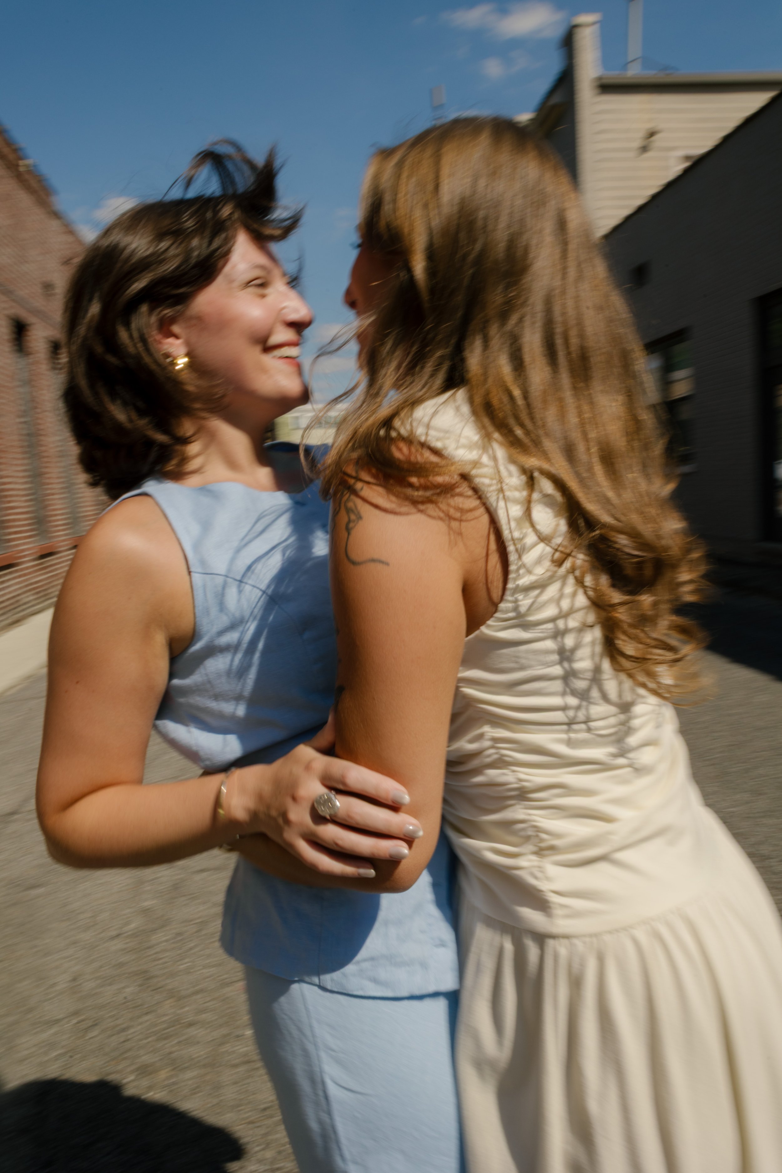Couple embraces in the middle of a quiet city street during candid wedding portraits.