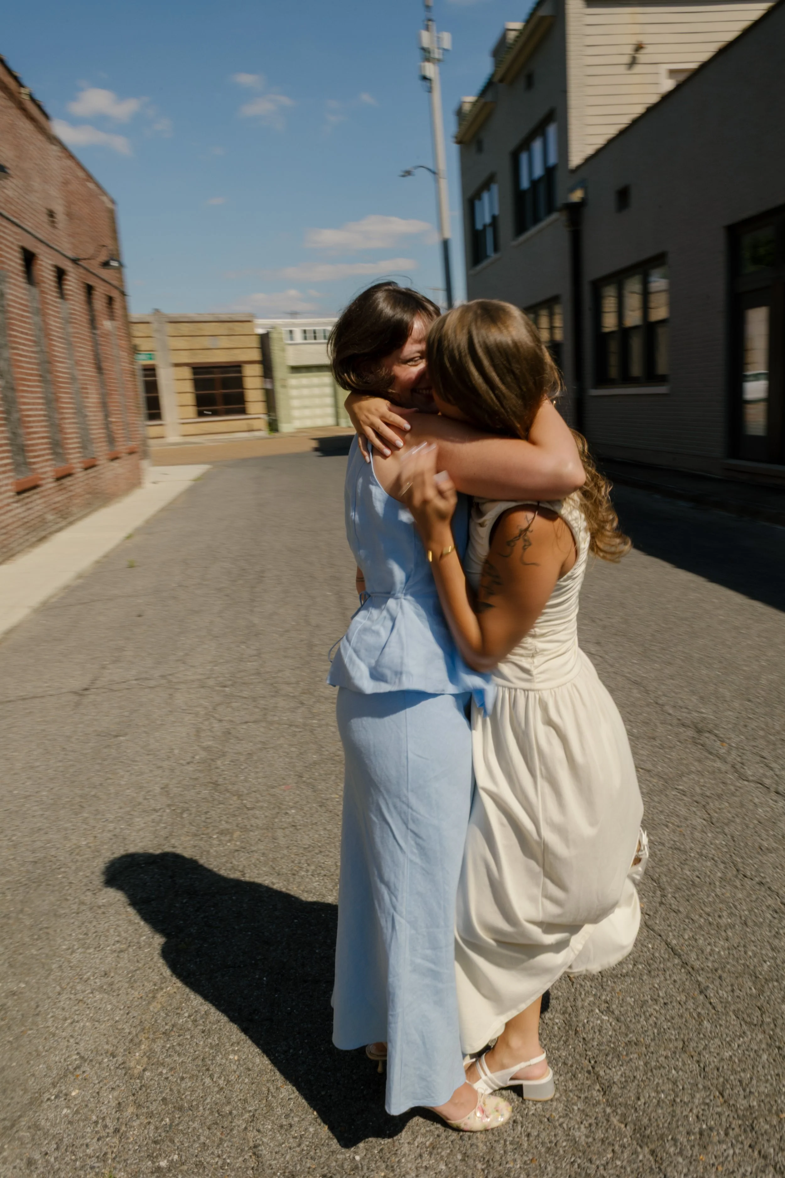 Joyful embrace between newlyweds in the middle of a quiet city street.