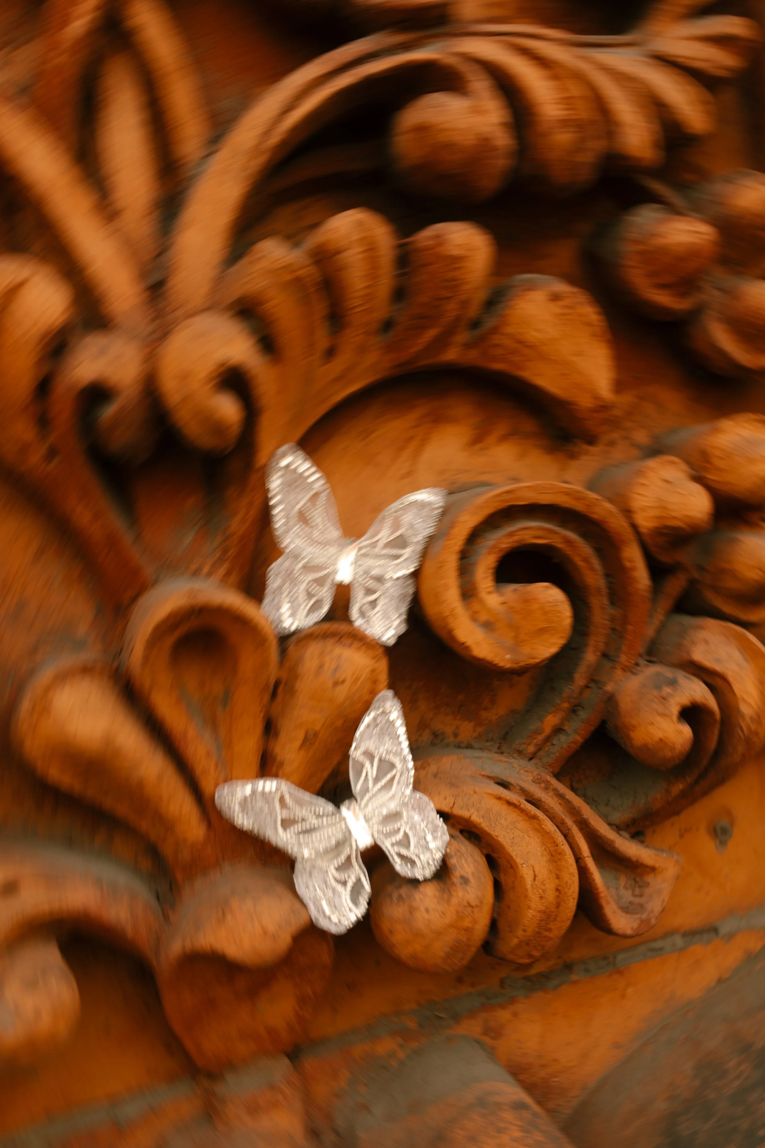 Butterfly-shaped bridal accessories photographed against ornate architectural details.