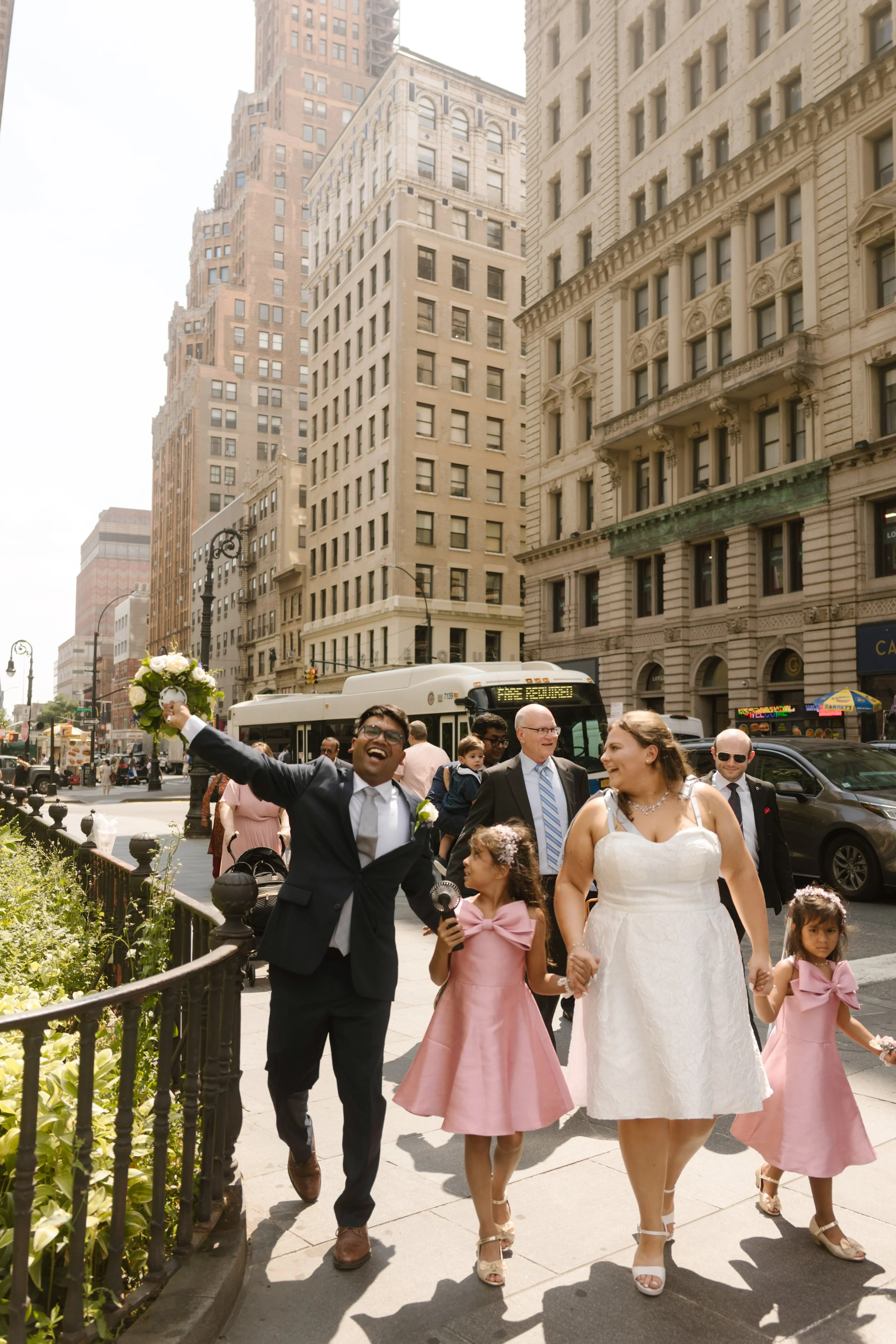 Family walks through Lower Manhattan after a courthouse wedding, celebrating together in the heart of New York City.