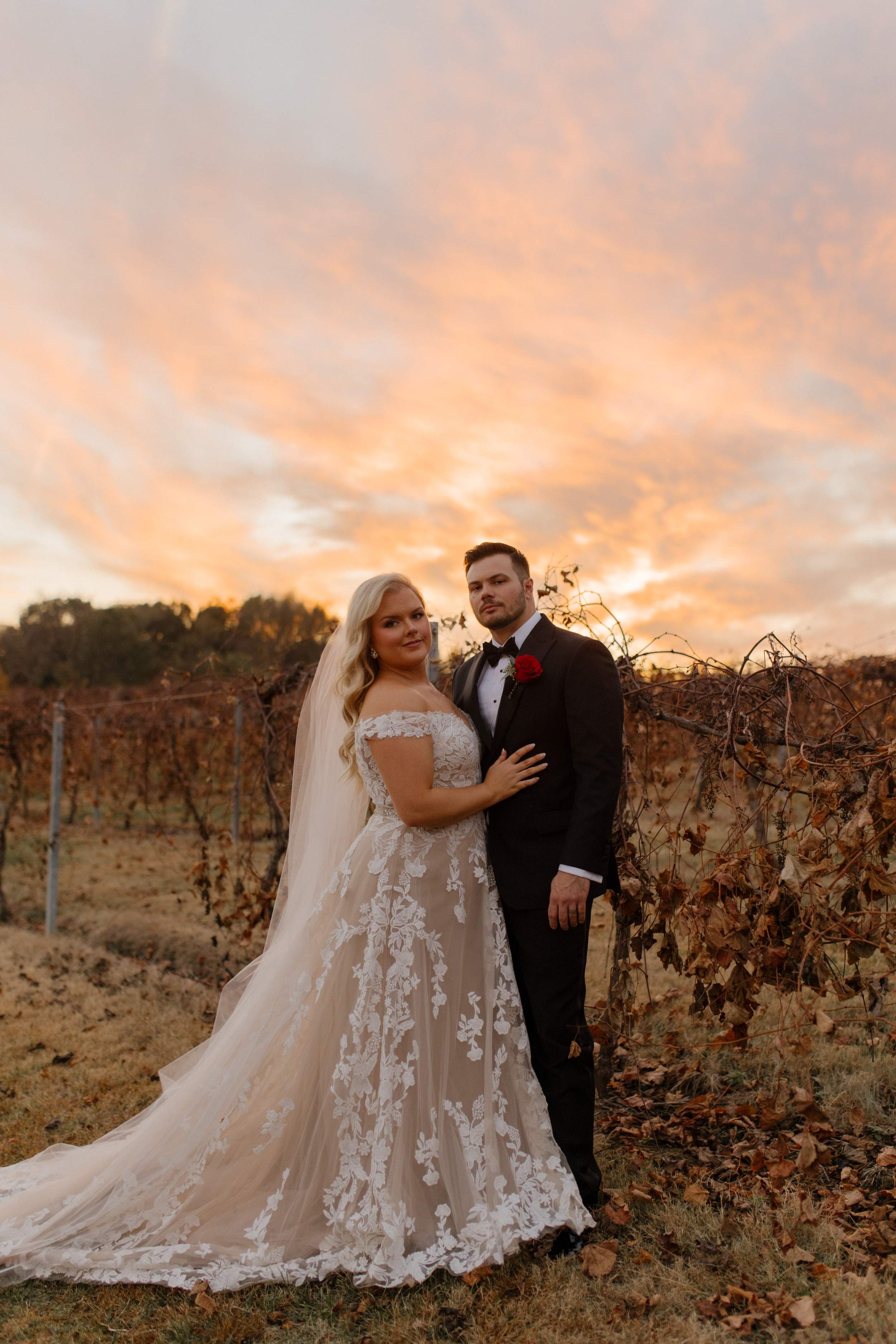 Bride and groom posing in a vineyard at sunset during their Multi-Day Destination Wedding weekend