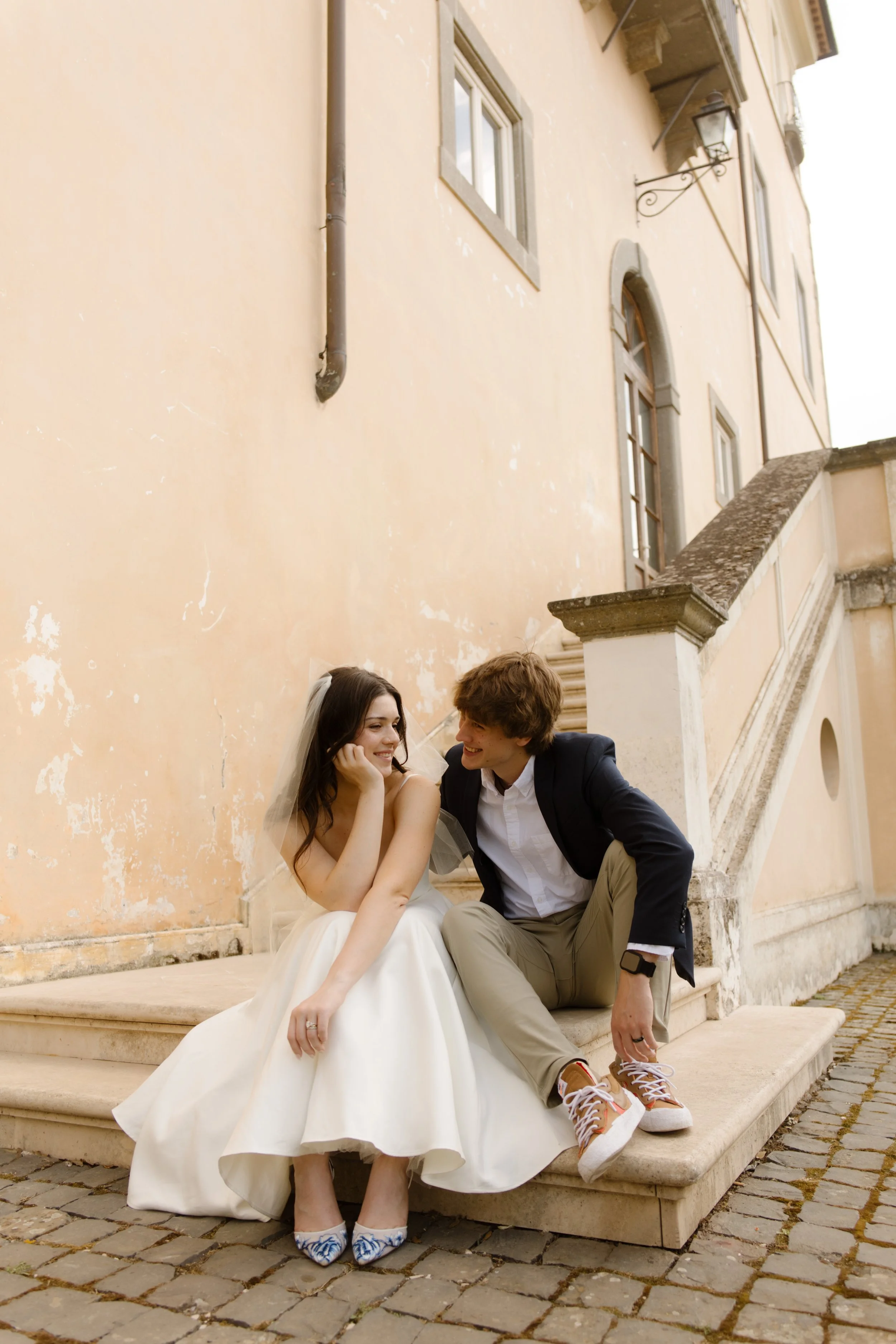 Newlywed couple sitting together on stone steps during their Multi-Day Destination Wedding in Italy