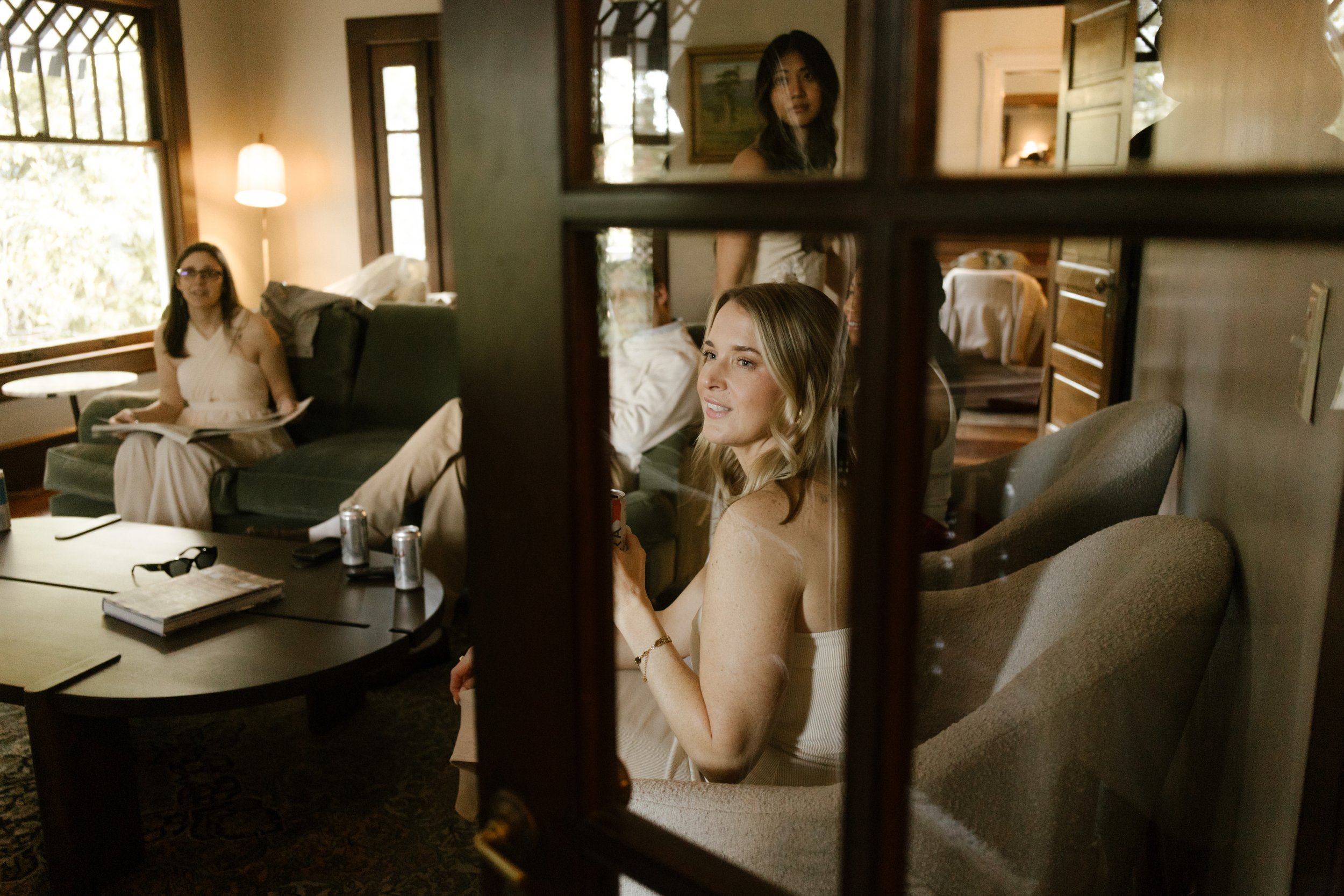 Candid wedding weekend photo of guests relaxing together inside a cozy home before the celebration