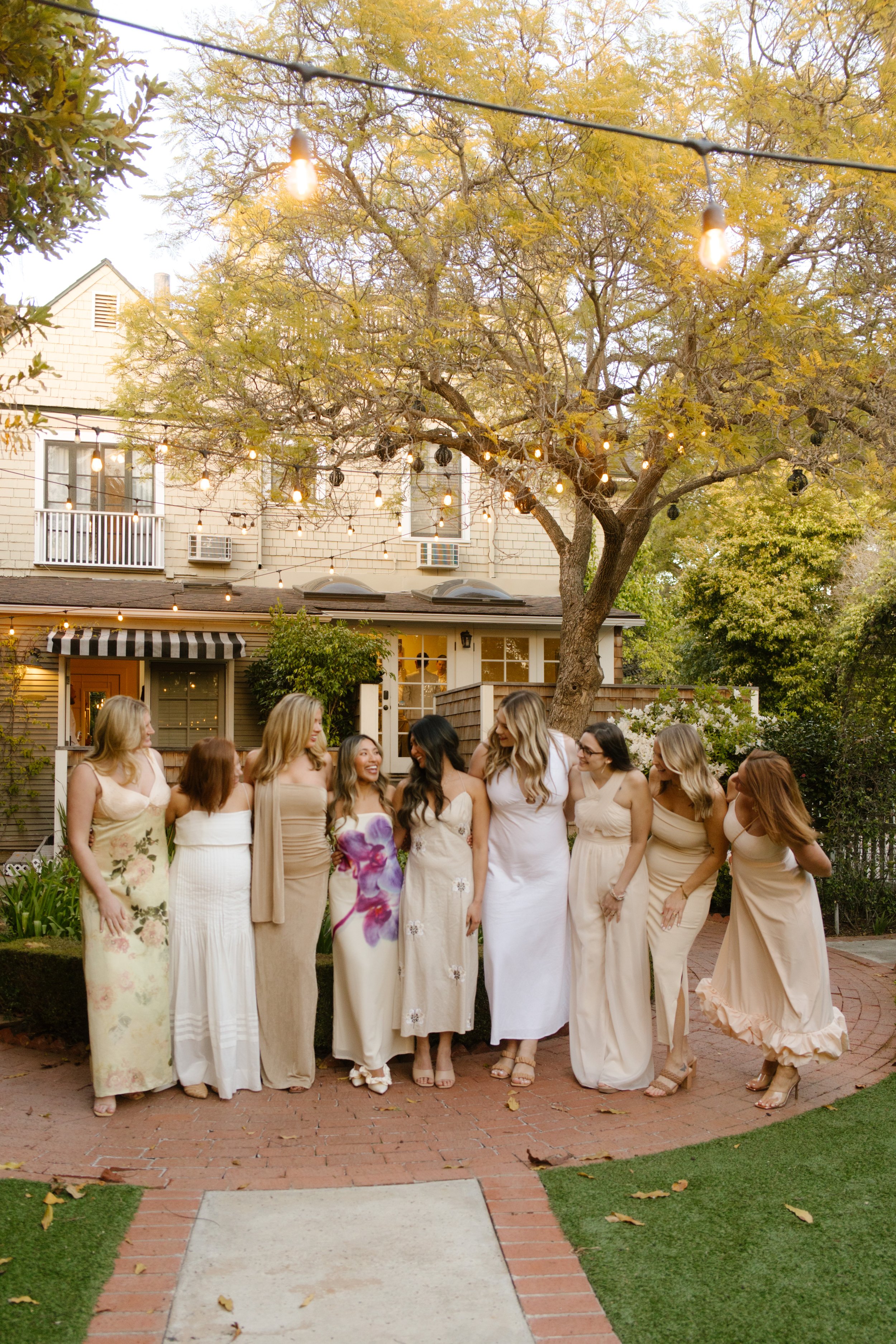 Wedding guests laughing together beneath string lights during a relaxed Multi-Day Destination Wedding weekend