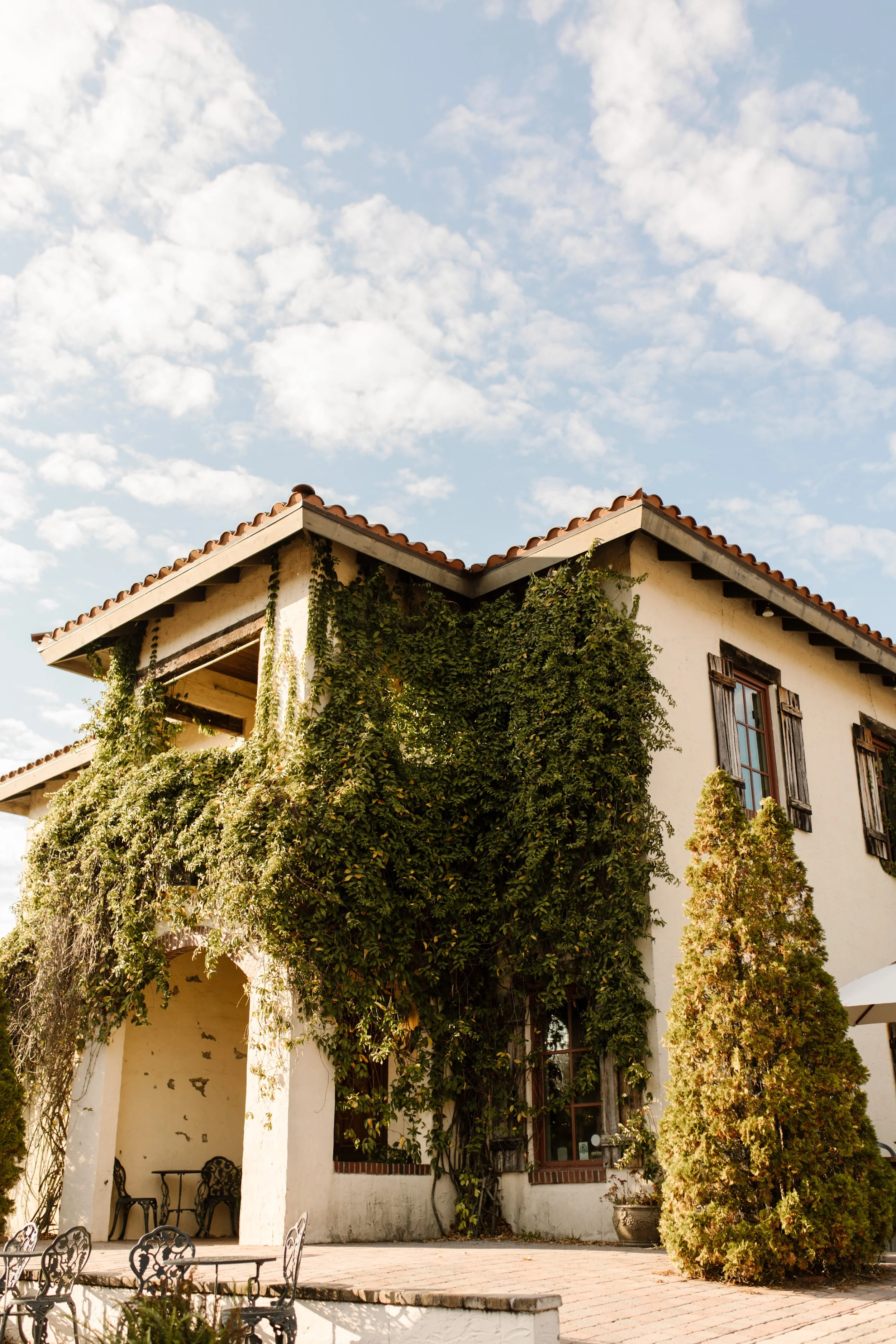 Ivy-covered villa surrounded by greenery and outdoor gathering spaces for an intimate destination wedding