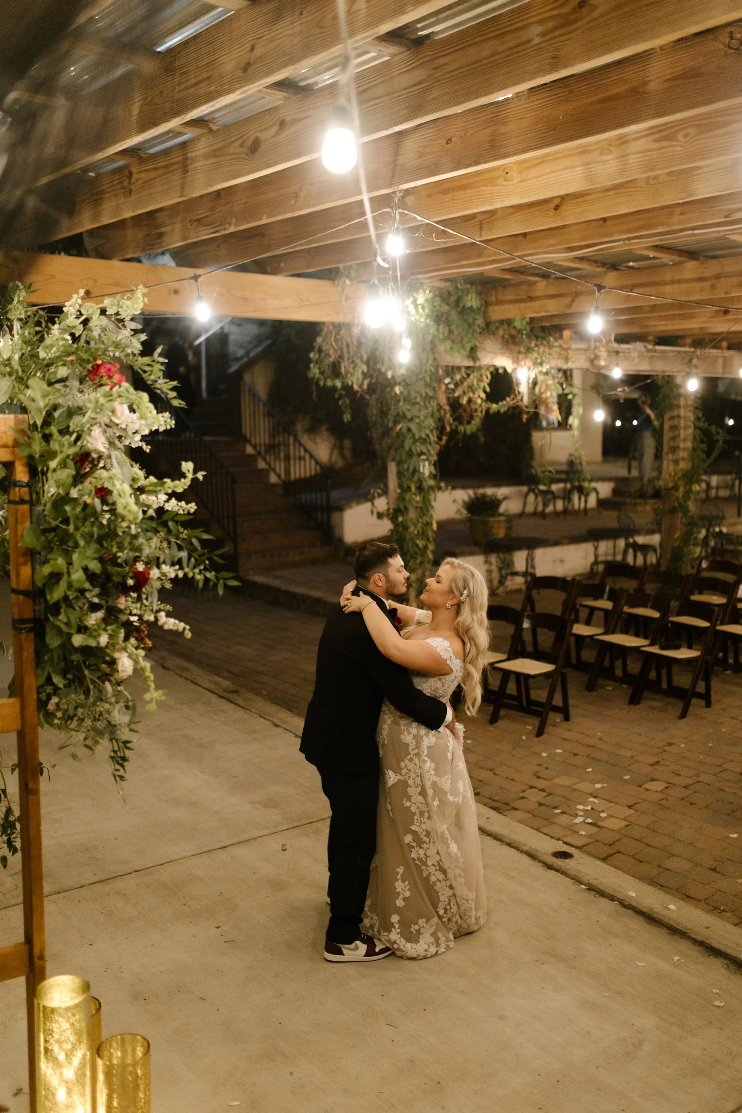 Bride and groom dancing together beneath string lights during their Multi-Day Destination Wedding reception