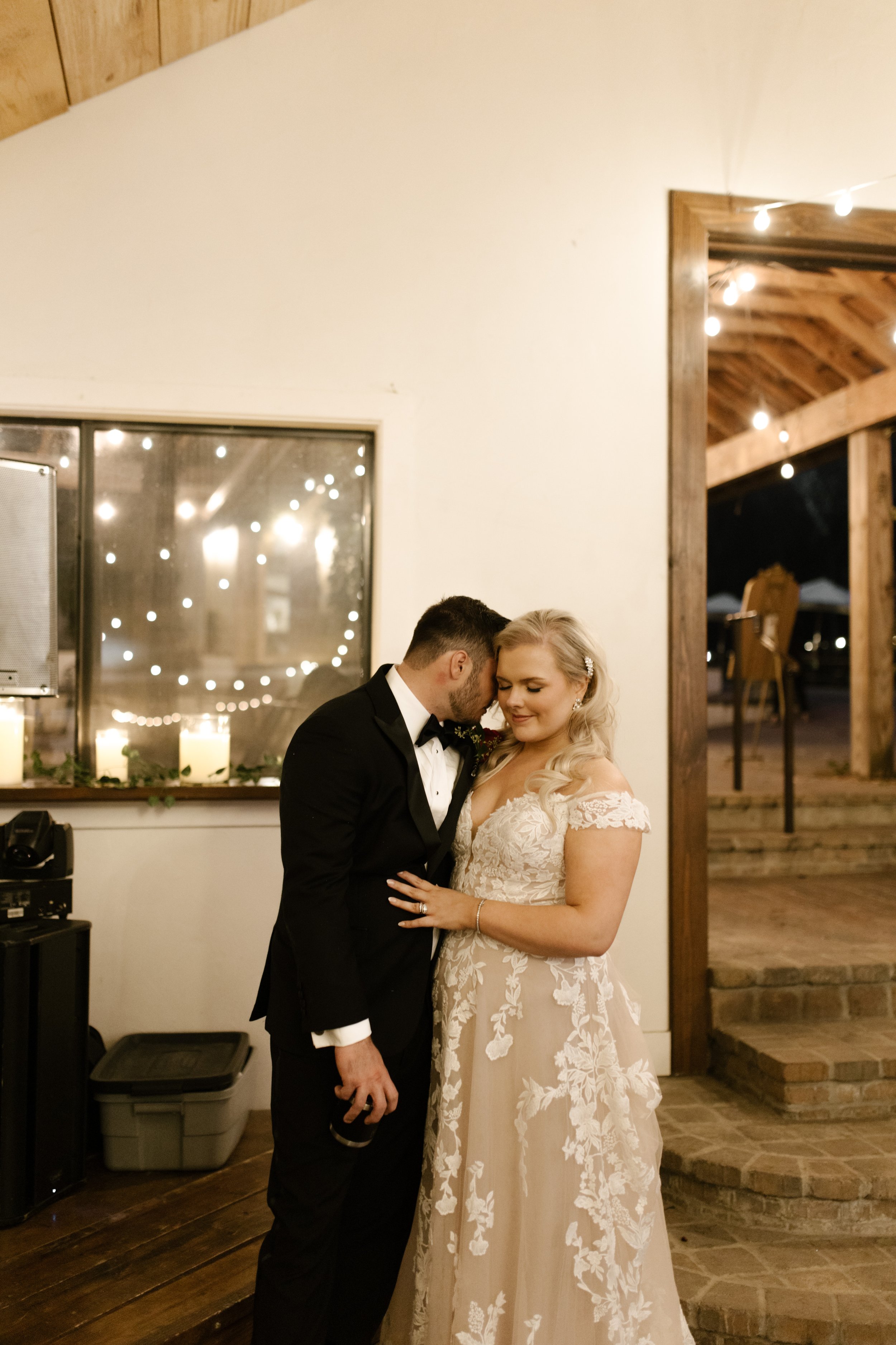 Newlywed couple sharing a quiet moment beneath string lights during their Multi-Day Destination Wedding reception