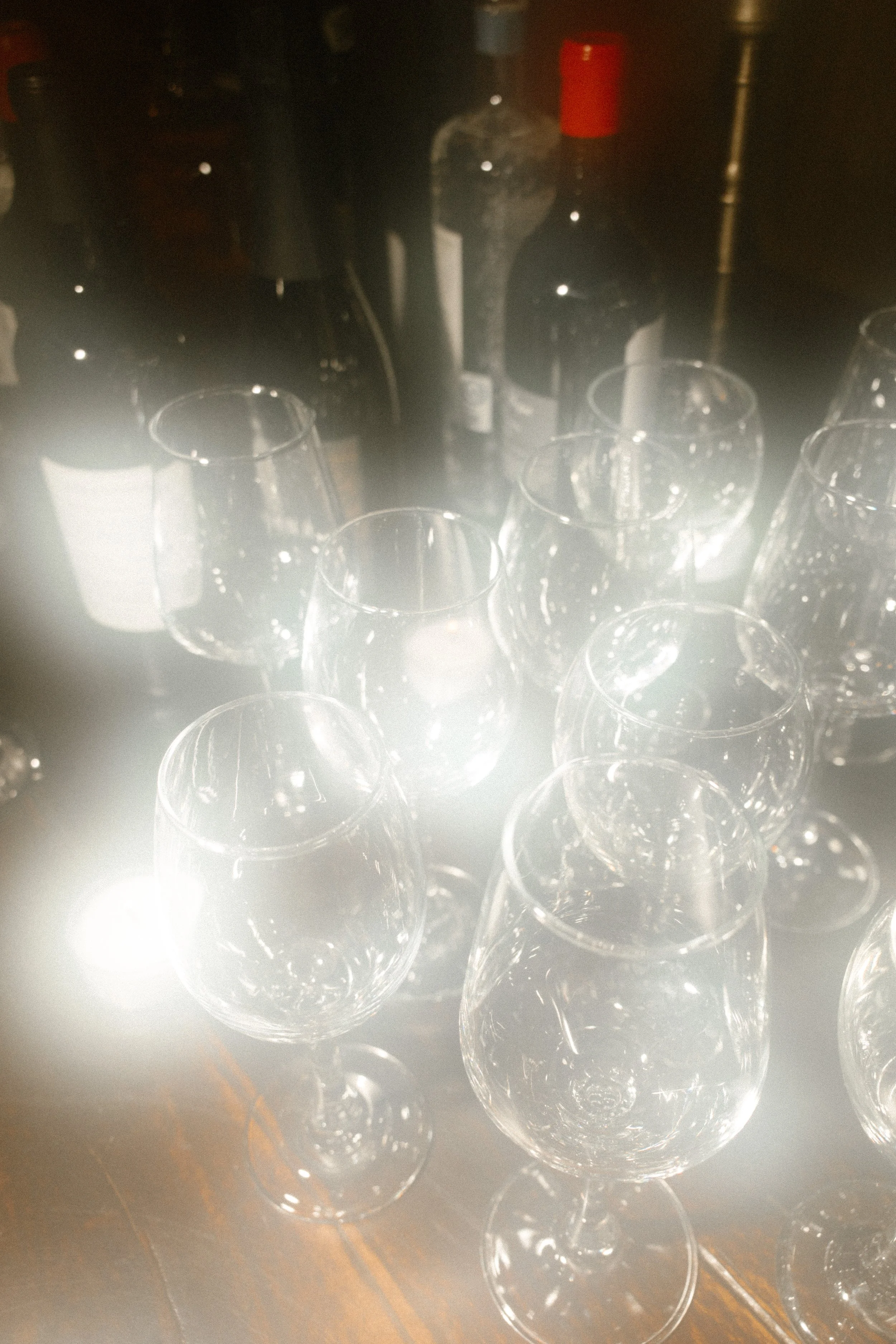Wine glasses glowing in warm light during an intimate destination wedding dinner