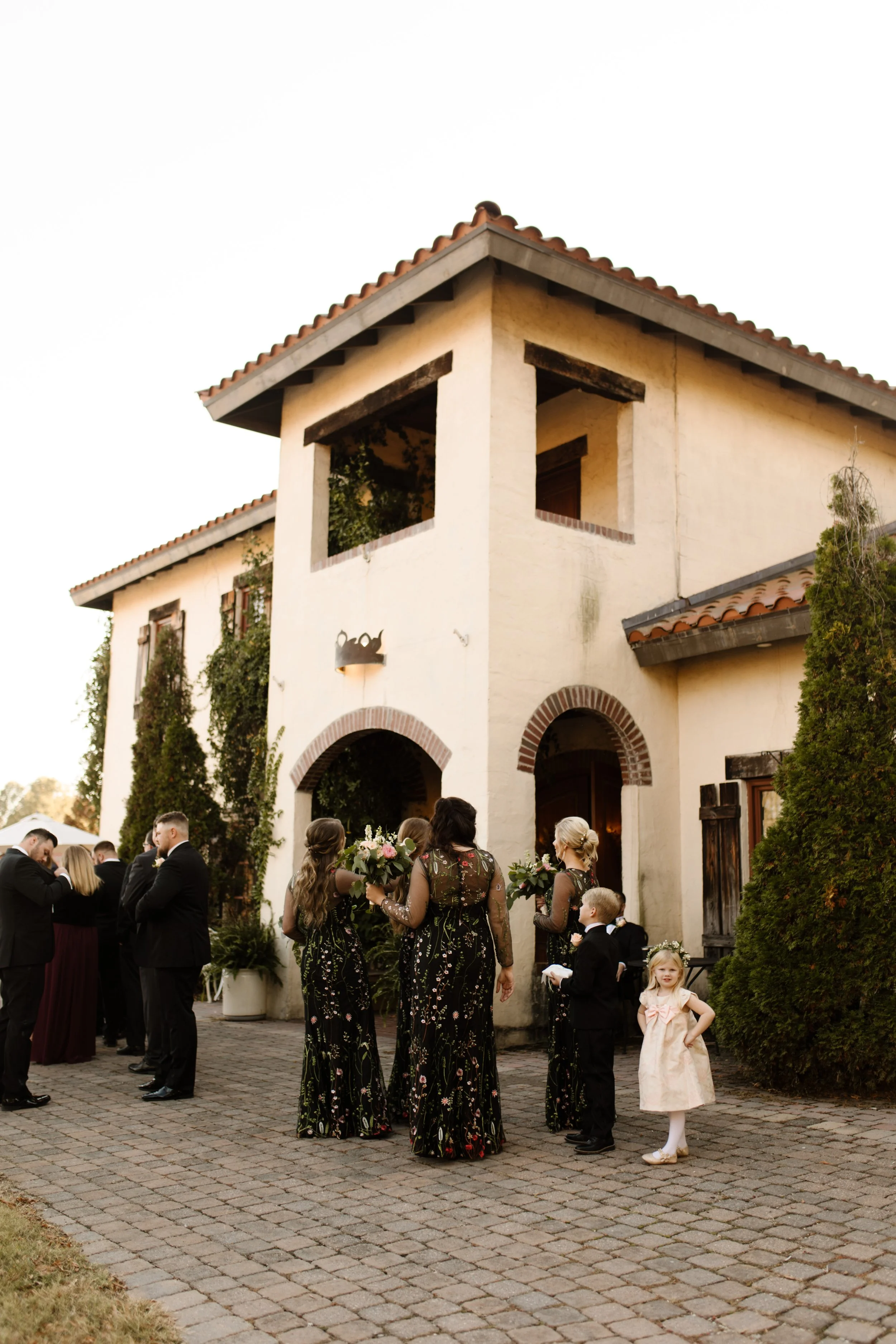 Wedding guests gathering outside an ivy-covered venue before an intimate wedding ceremony