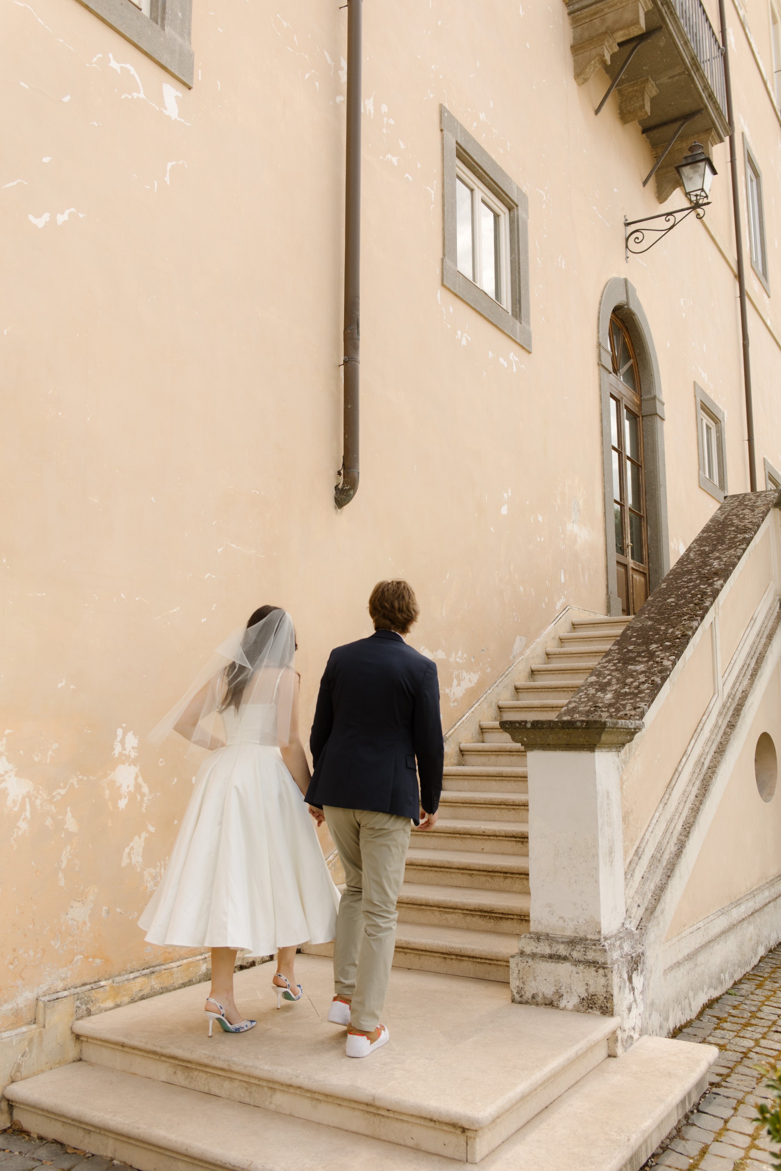 Multi-Day Destination Wedding couple walking up the steps of a historic Italian villa during their wedding weekend