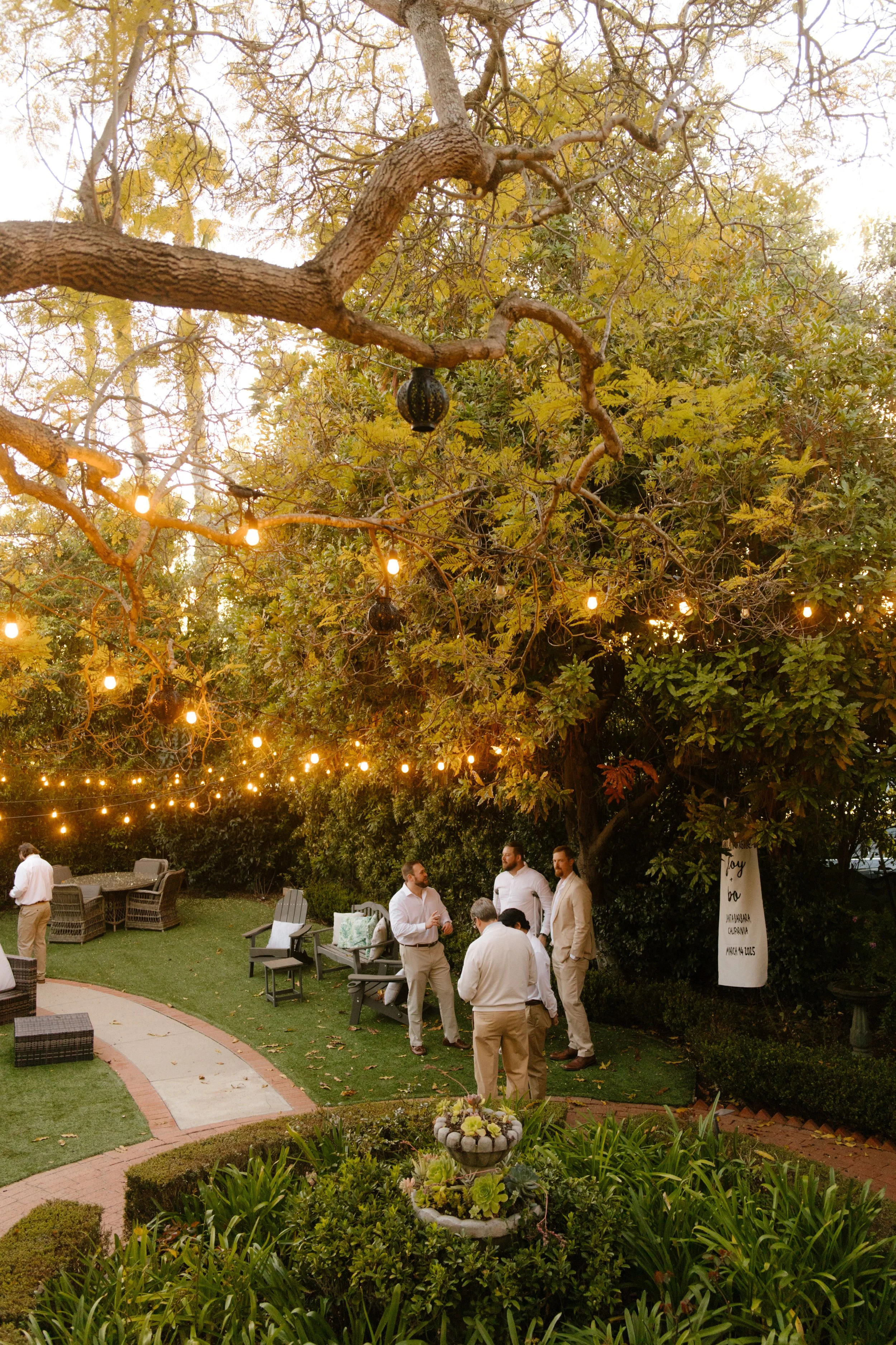 Wedding guests gathering beneath string lights in a garden during a relaxed Multi-Day Destination Wedding celebration