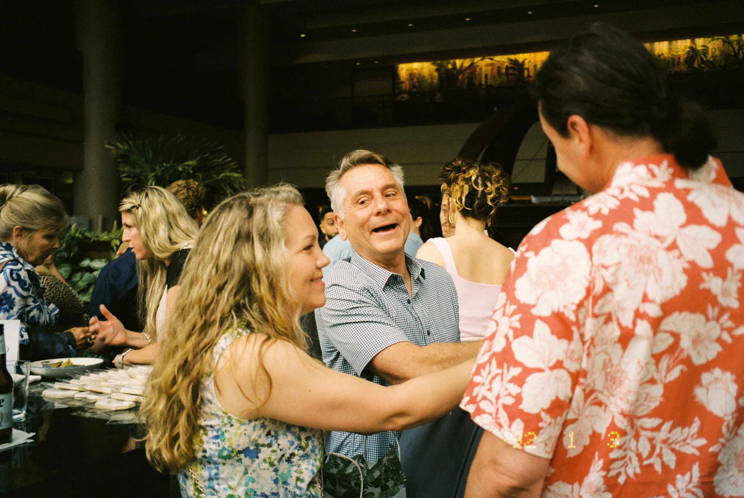 Guests laughing and catching up together during the wedding rehearsal dinner.