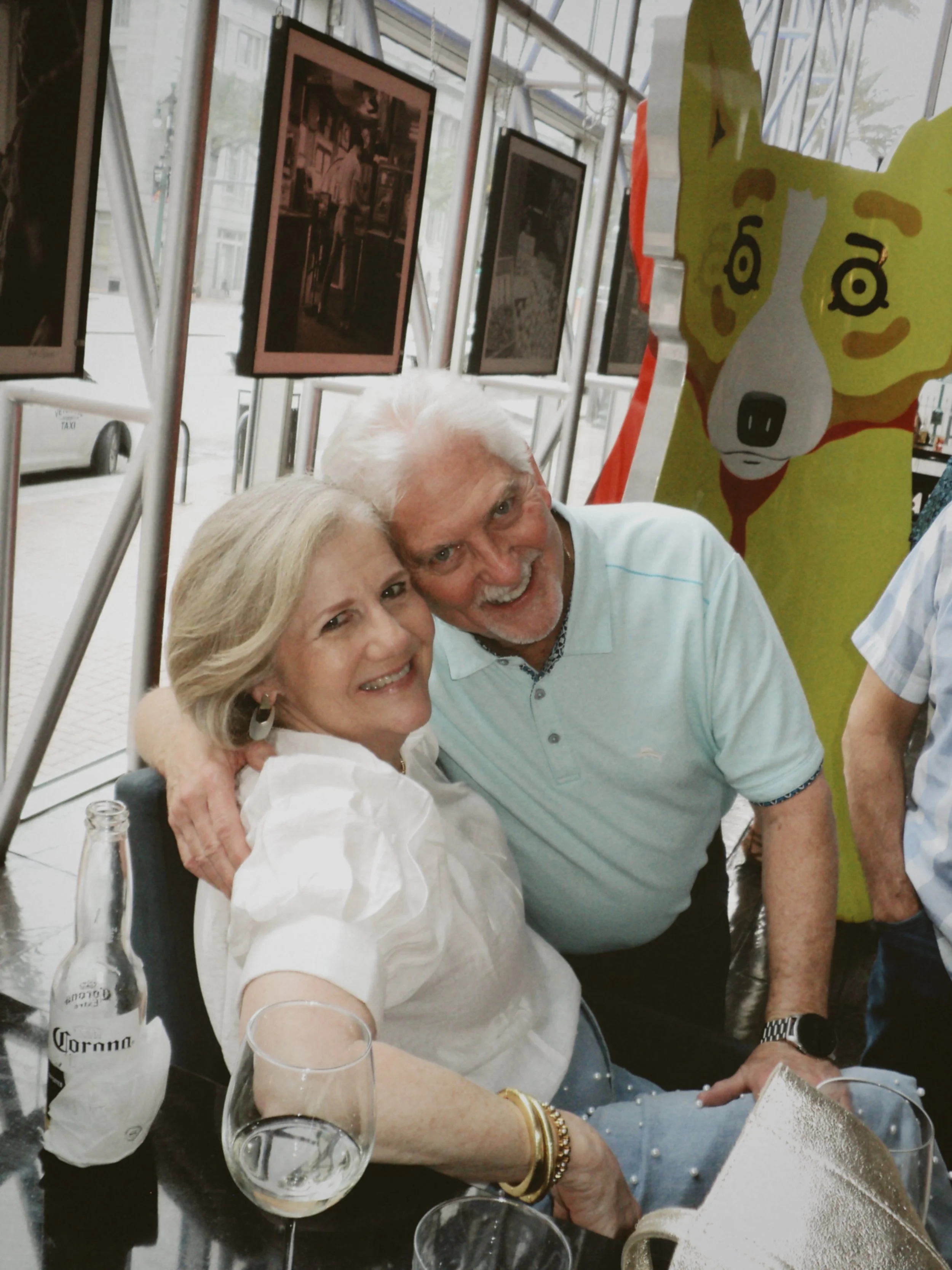 Older couple smiling together while enjoying drinks at a pre-wedding gathering.
