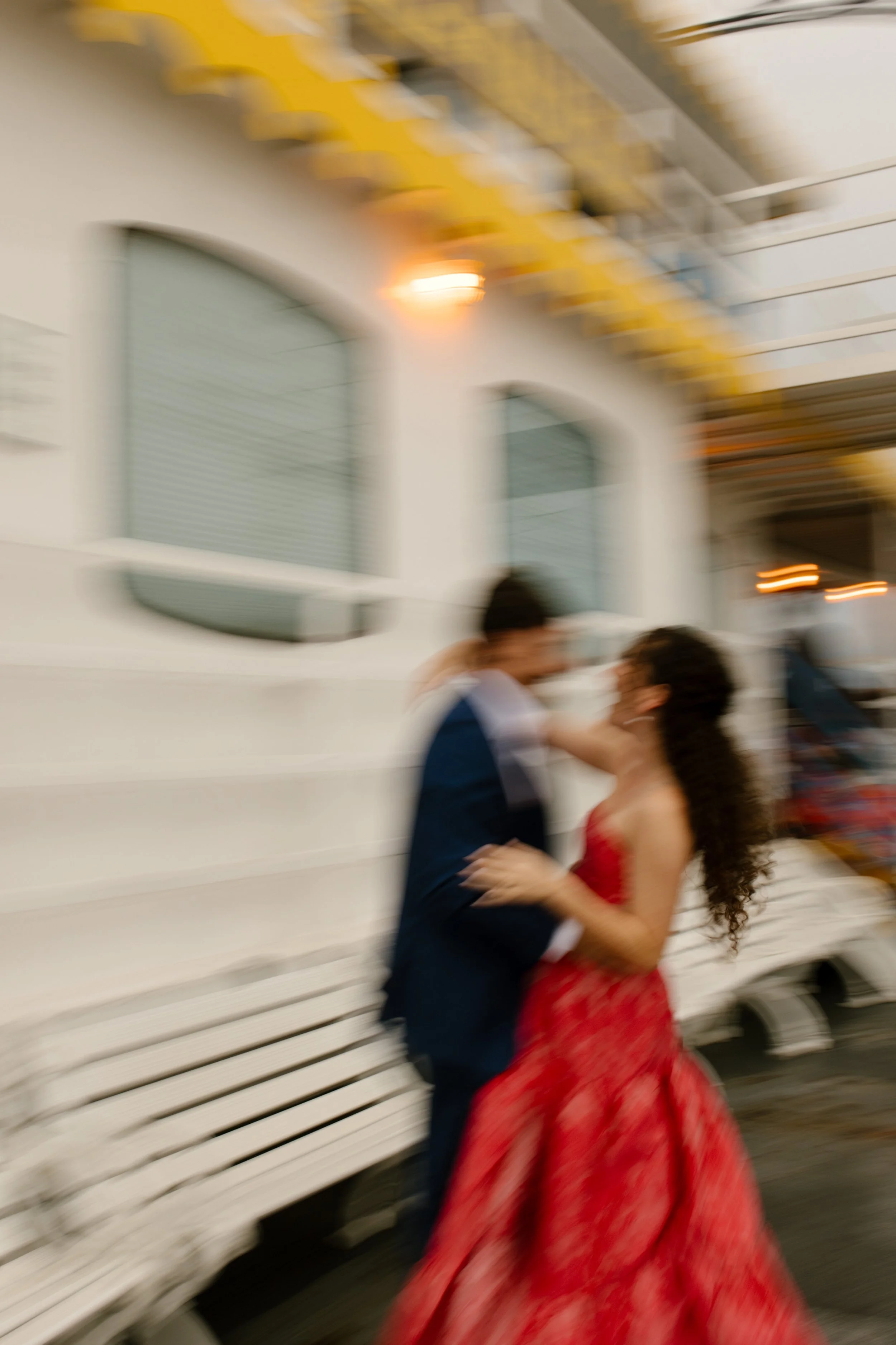Motion-blur photo of the couple laughing and dancing together on the riverboat deck.