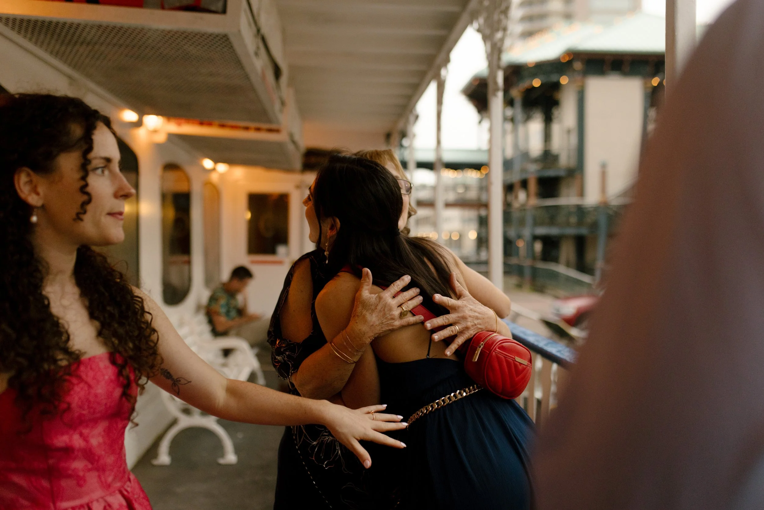Family members greeting each other with a hug on the riverboat deck before the celebration.