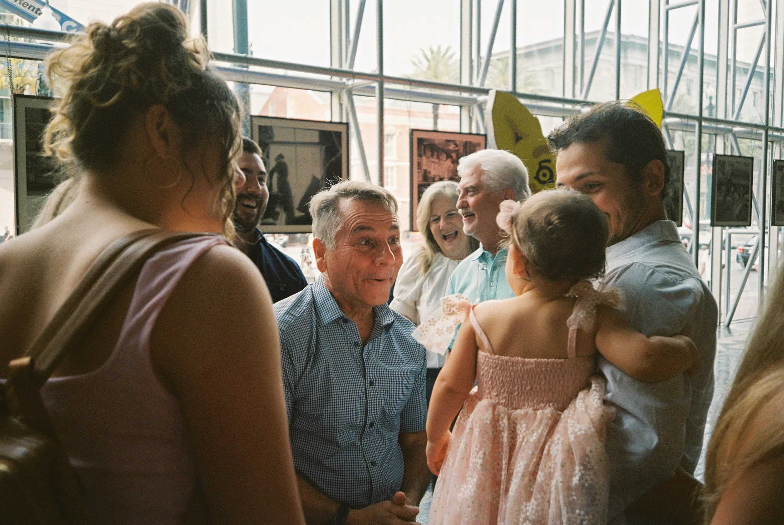 Guest reacting playfully while chatting with family members during the wedding rehearsal dinner.